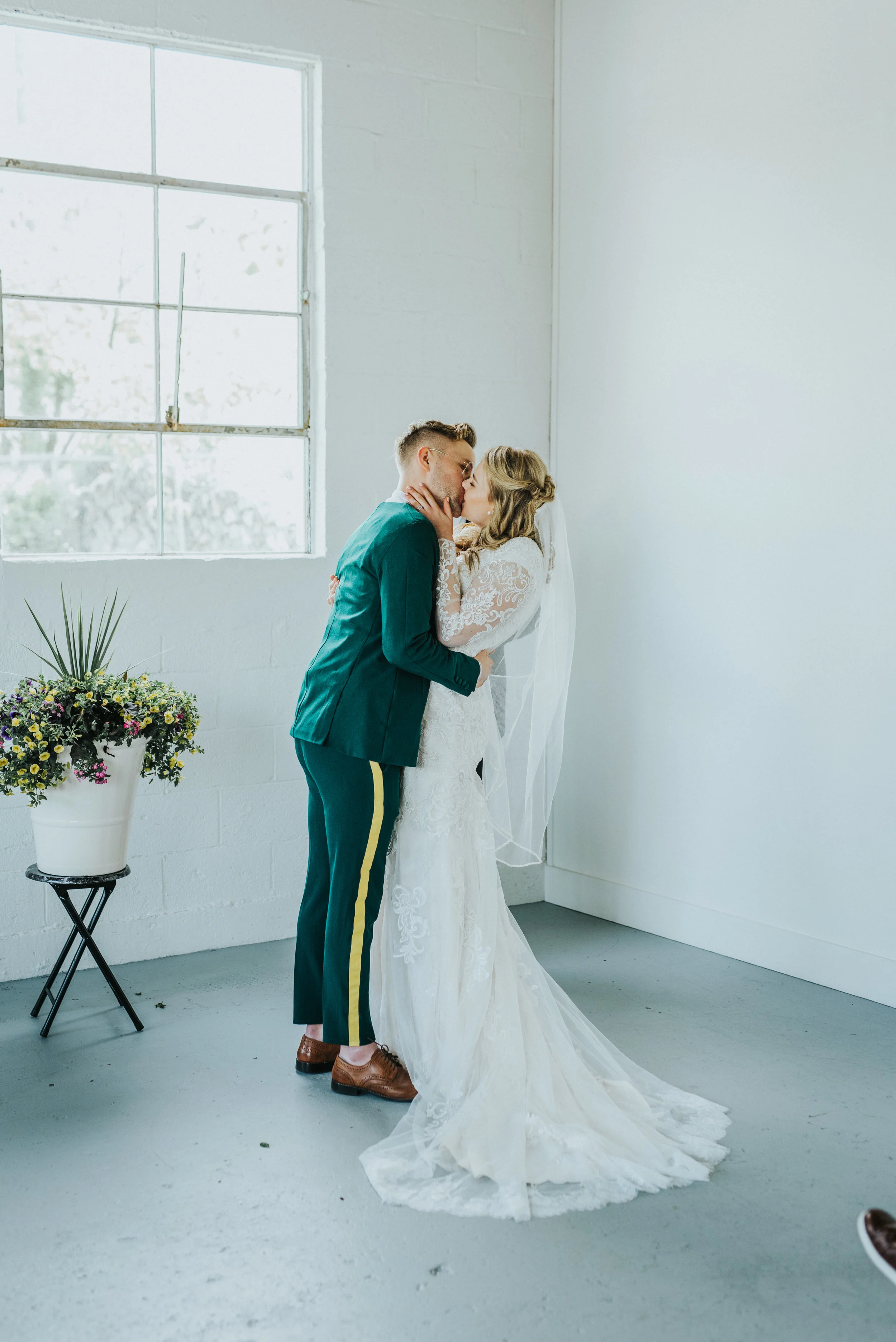  professional logan utah wedding photographer cache valley utah white studio wedding ceremony civil kissing i do just married emerald green retro wedding suit yellow striped pant modest wedding dress long lace sleeved wedding dress romantic happy #St