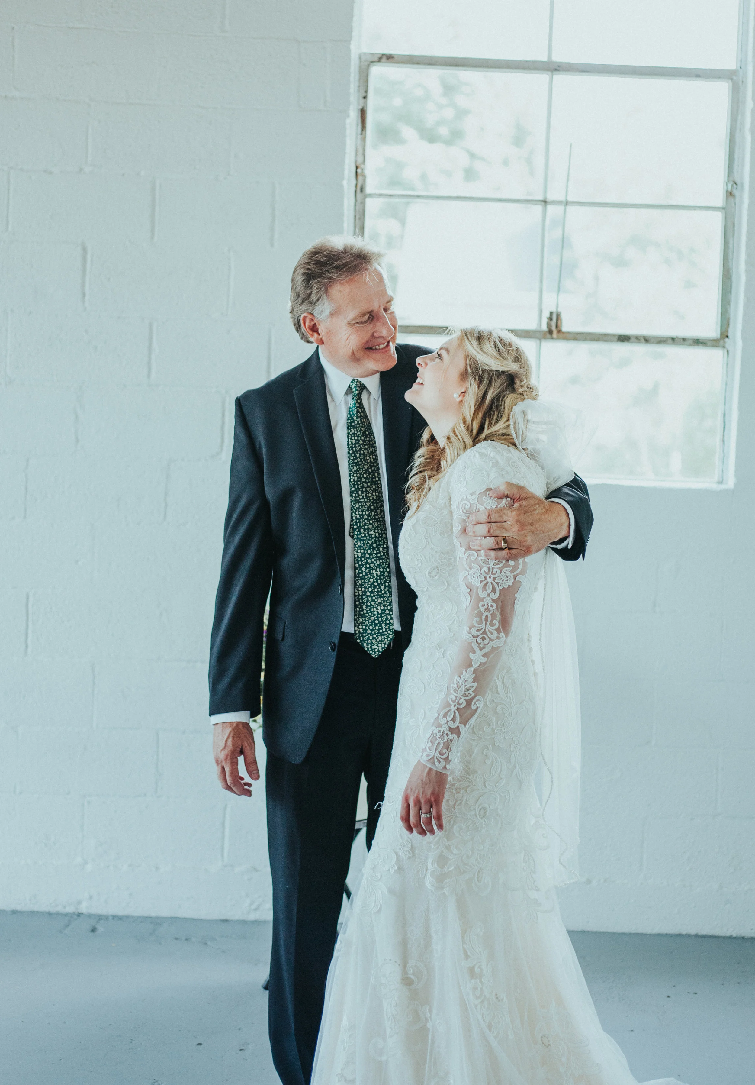  white brick studio wedding ceremony minimalist father of the bride hugging just married officiant family happy professional logan utah wedding photographer #StationStudio #WeddingCeremony #Loganutahtemple #FreckleFarm #cachevalleyutah #utah #ido #we