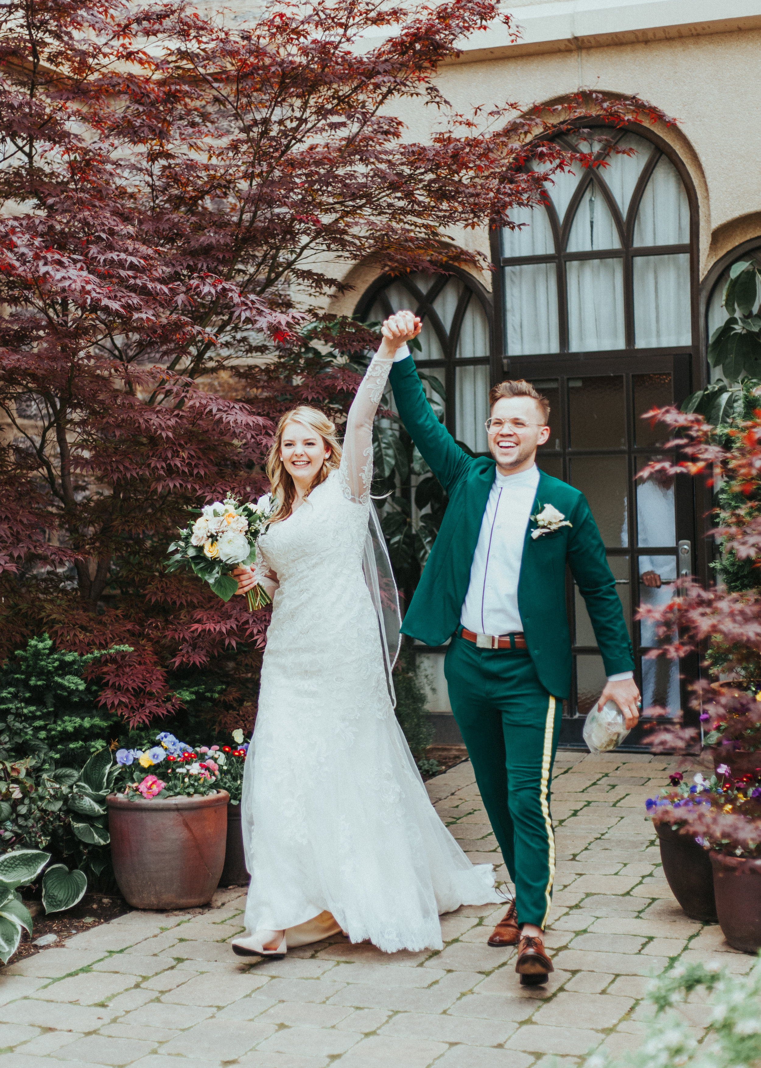  wedding exit professional logan utah wedding photographer logan utah lds temple wedding sealed for eternity holding hands smiling celebrating modest long sleeved lace wedding dress emerald green retro wedding suit yelloe wedding bouquet loose curled