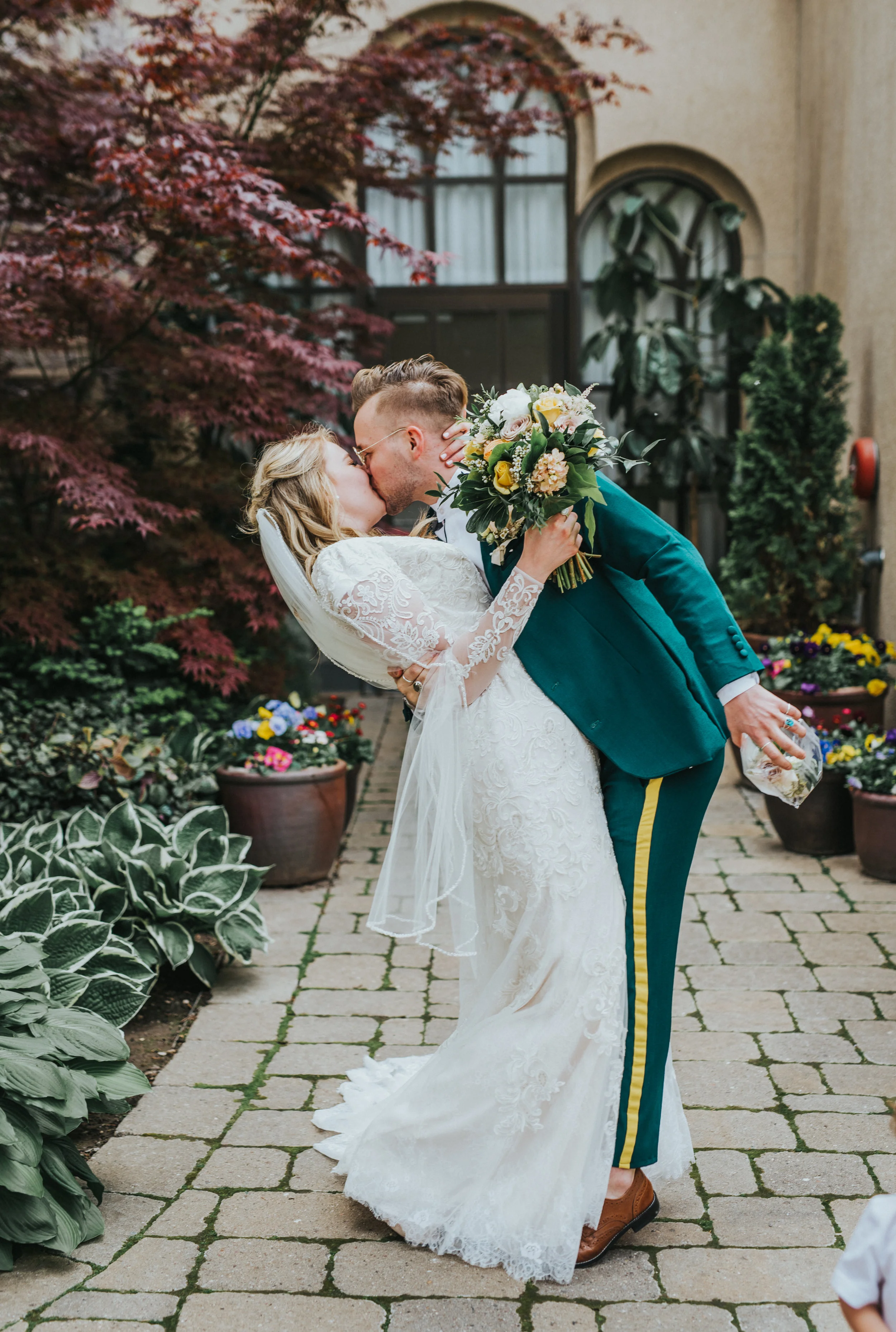  kidding dipped hugging wedding exit professional logan utah wedding photographer logan utah lds temple wedding sealed for eternity holding hands smiling celebrating modest long sleeved lace wedding dress emerald green retro wedding suit yelloe weddi