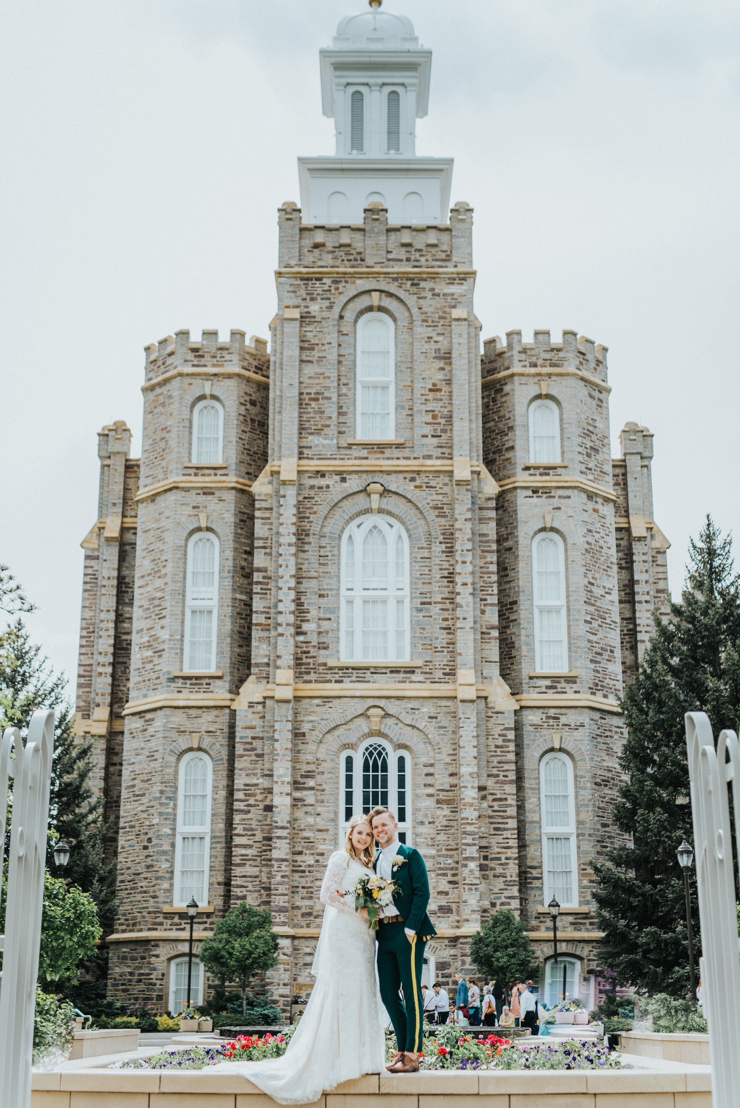  overcast logan utah lds temple wedding day husband and wife happy just married temple grounds emerald green retro wedding suit professional logan utah wedding photographer long sleeved lace wedding dress modest #StationStudio #WeddingCeremony #Logan