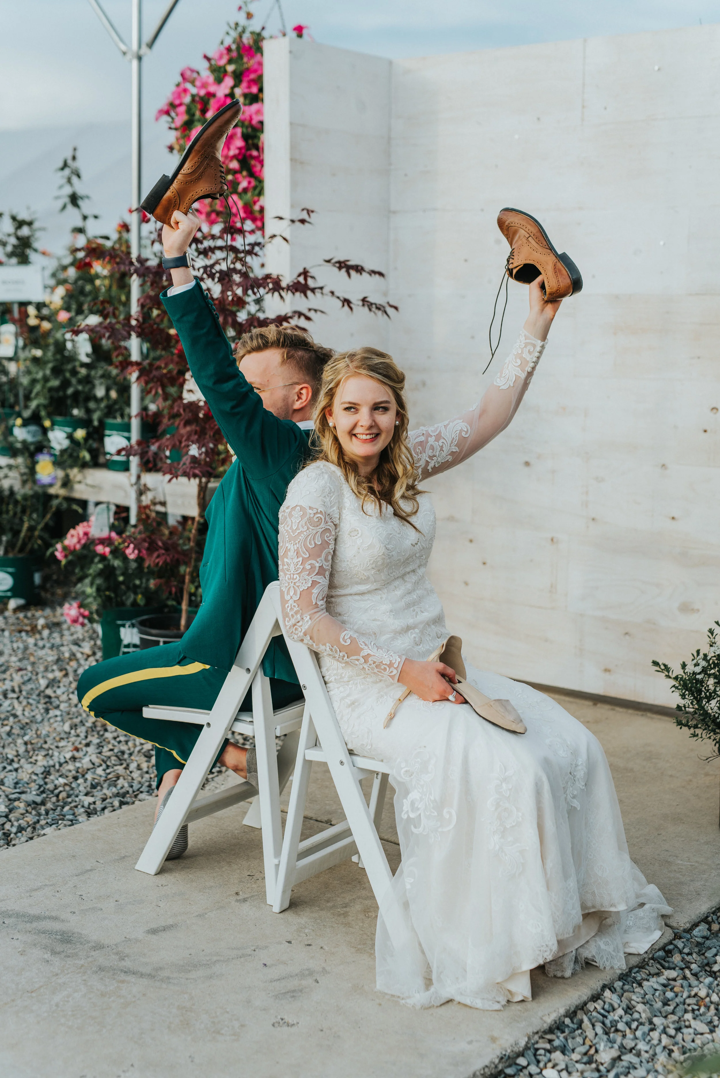  freckle farm outdoor wedding reception emerald green wedding suit retro vintage mens glasses brown leather belt wedding shoes modest lace long sleeved wedding dress professional logan wedding photographer white wedding chair gravel ground happy #Sta