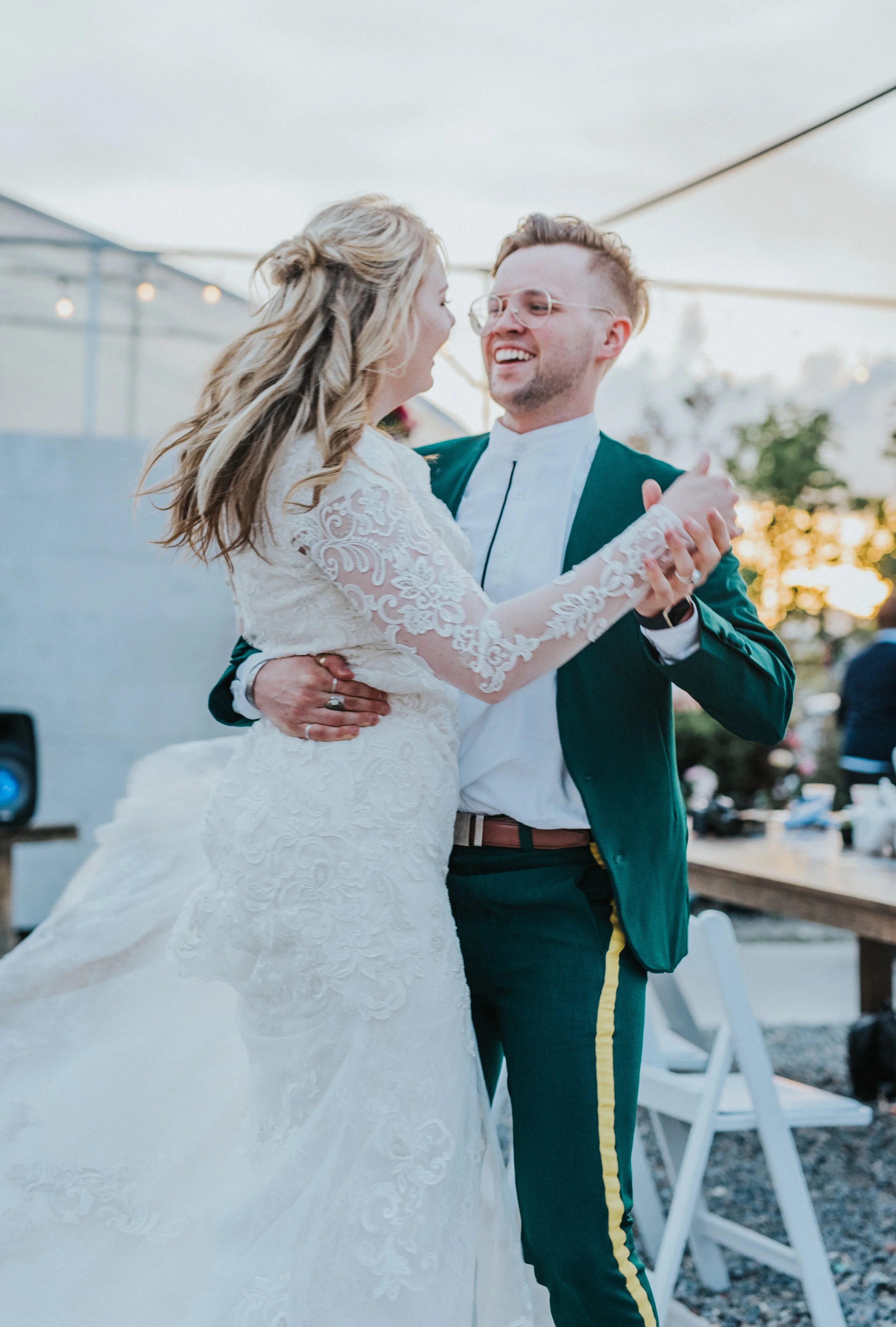  outdoor wedding reception freckle farm reception professional logan utah wedding photographer modest lace long sleeved wedding dress loose wedding curls first dance celebrating happy smiling spinning retro emerald green wedding suit yellow striped p