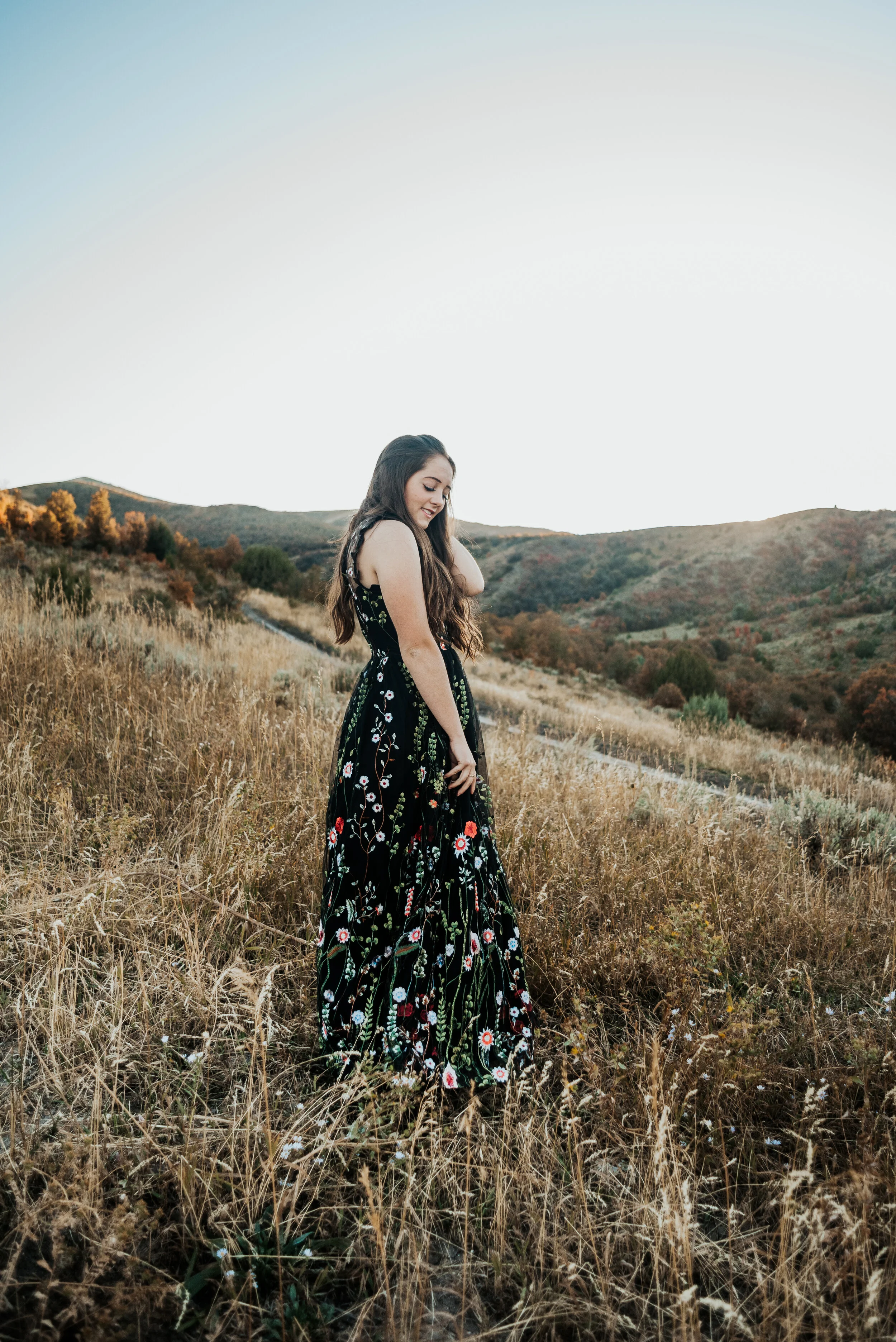  Teen girl posing in a field in Cache Valley in her black prom dress. senior in high school graduating class of 2020 professional photographers in utah cache valley senior photo poses logan utah photographers teen fashion senior pictures photo sessio