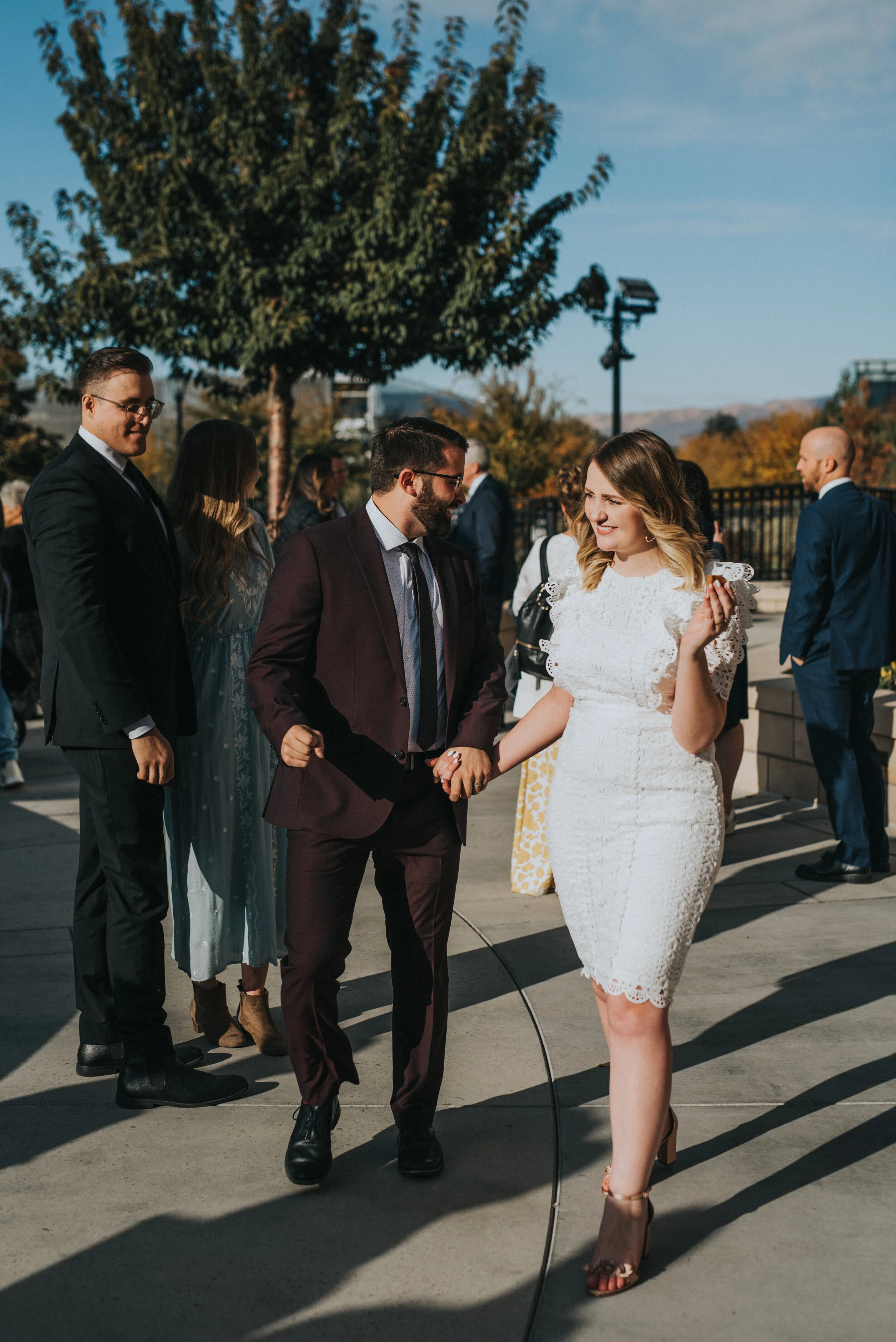  burgundy grooms suit trendy wedding knee length modest lace wedding dress retro holding hands wedding exit smiling happy professional provo utah wedding photographer utah valley photography provo city center temple lds sealing #utahvalleyweddingphot