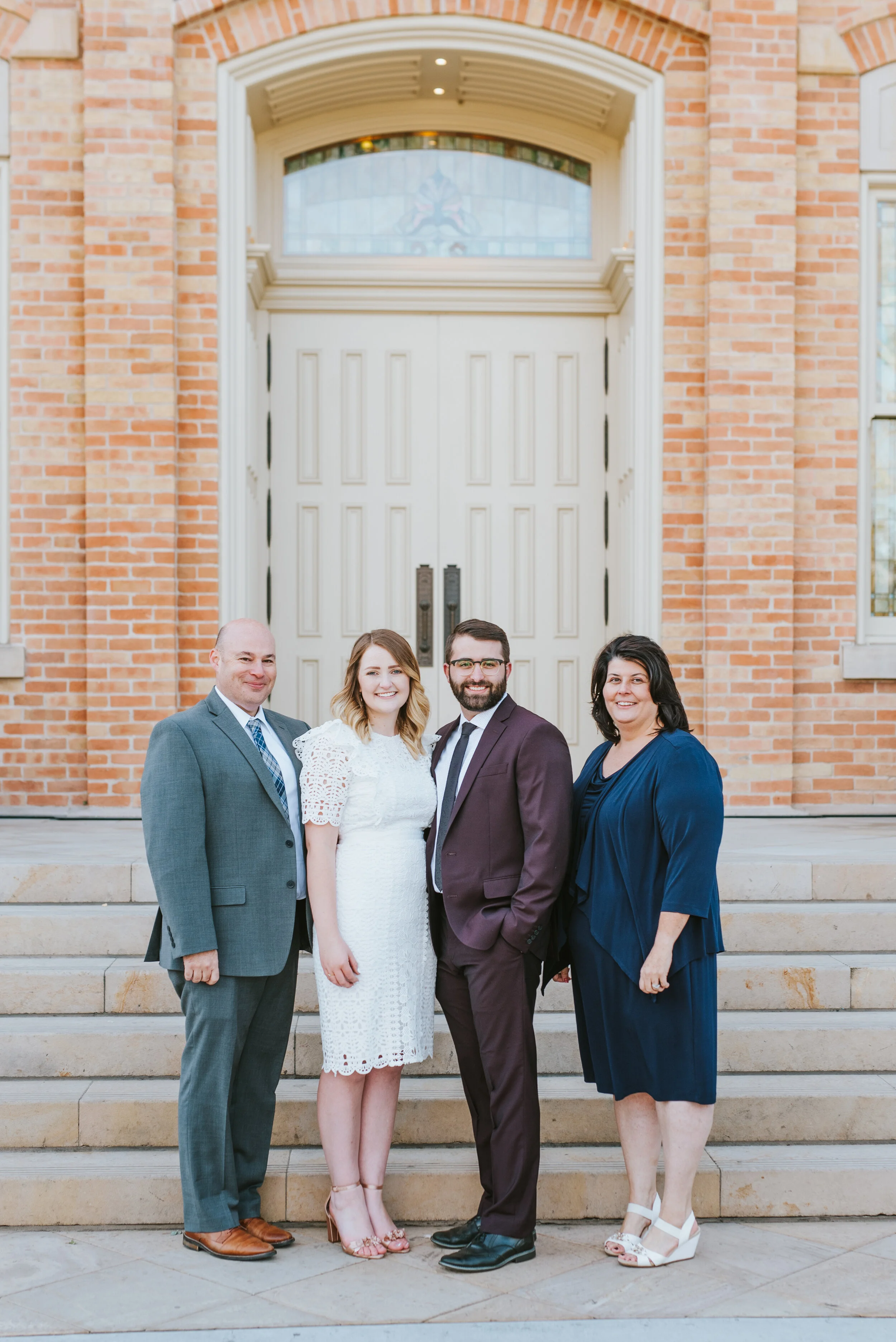  father of the bride mother of the bride wedding day happy smiling eternal families provo city center temple provo utah wedding photographer modest lace short sleeved knee length wedding dress wedding inspiration burgundy wedding suit #utahvalleywedd