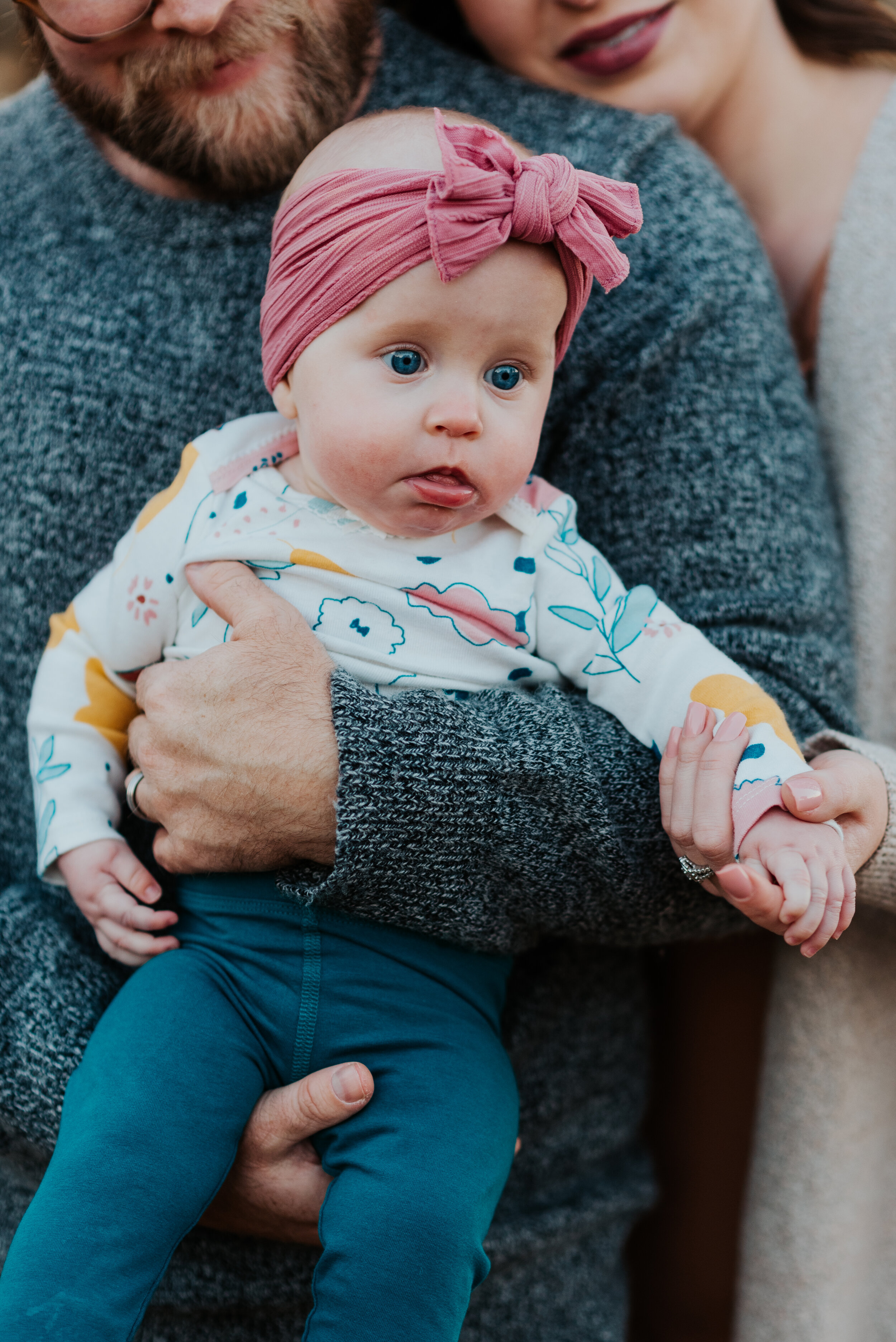  professional logan utah family photographer cache valley utah authentic family photos posing infant baby girl pink baby bling bow headband floral onsie dad holding baby girl holding baby’s hand hugging happy content #loganutah #loganutahphotographer