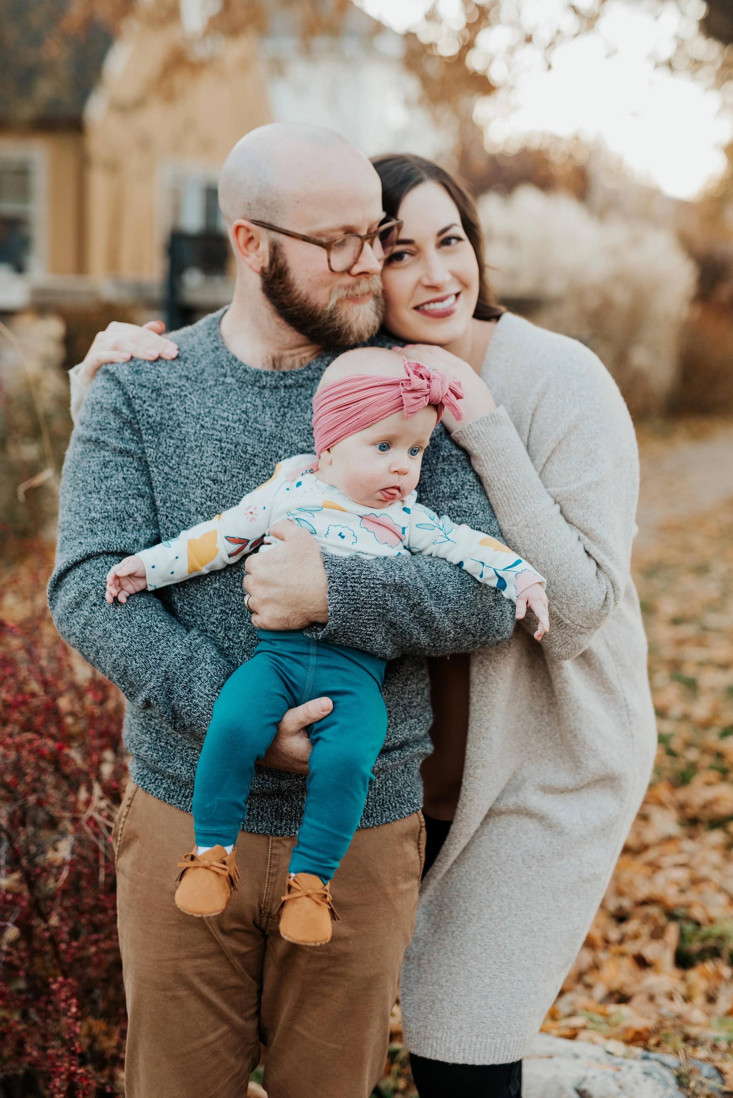 brown baby girl moccasins pink baby bling headband authentic family posing photos professional logan utah family photographer fall colors crinkly leaves hugging smiling happy yellow fall leaves #loganutah #loganutahphotographer #cachevalleyphotograp
