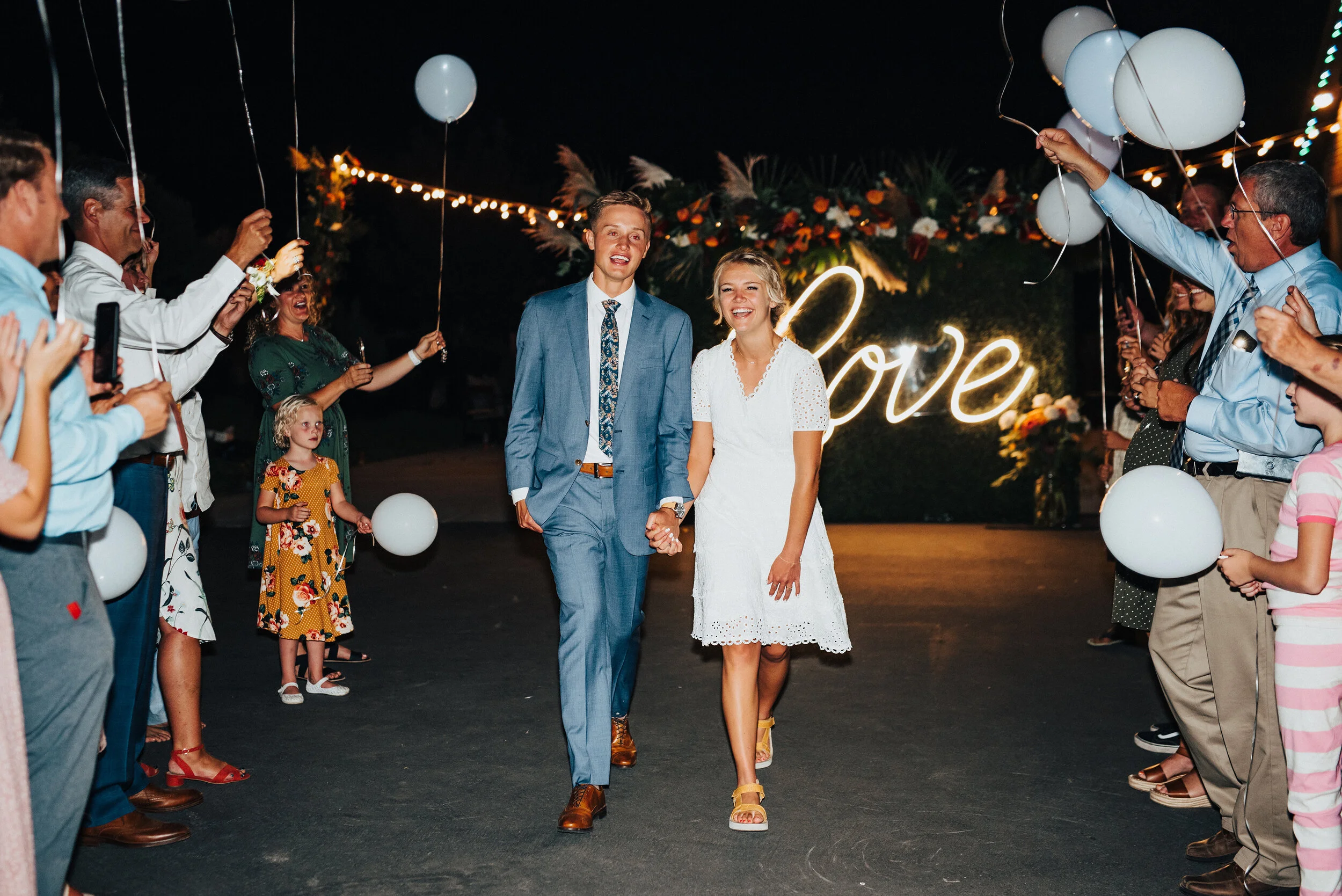 Glowing newlyweds exiting their wedding reception in Park City Utah. Kristi Alyse Photography Logan Utah photographer Park City wedding photographer Drive-Thru wedding COVID wedding neon signs socially distant wedding exit bride and groom #kristialy…