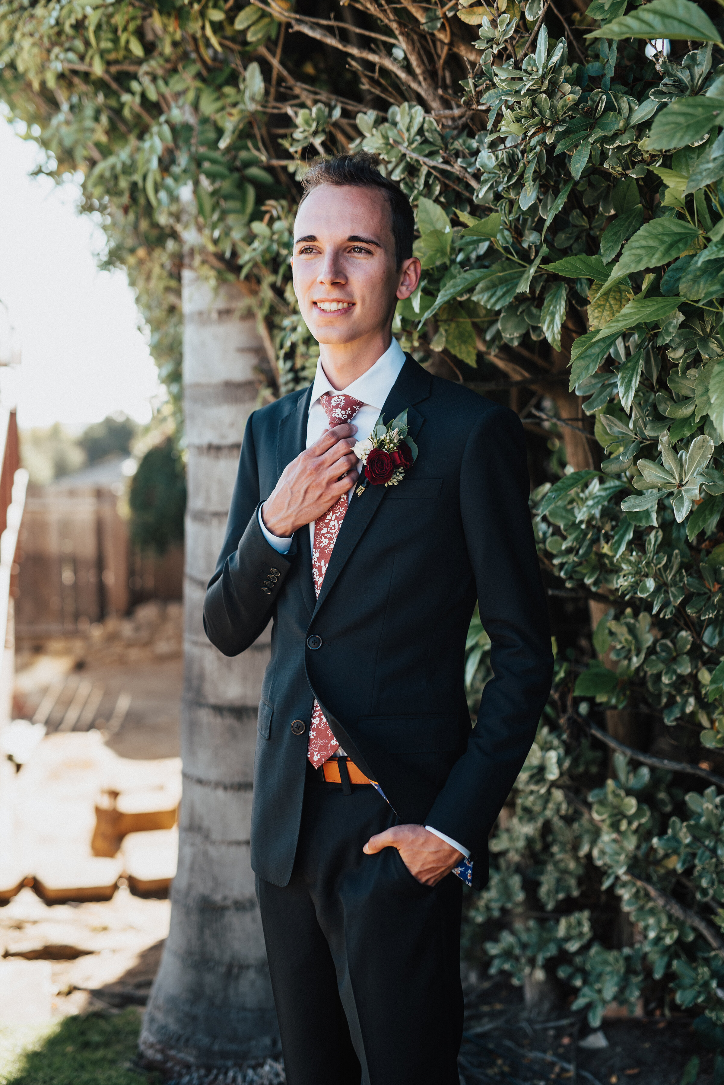  Handsome groom in a black suit and floral tie for his intimate backyard wedding in Laguna Beach. Kristi Alyse photography Laguna Beach wedding California brides Logan Utah wedding photographer backyard wedding destination photographer covid wedding 
