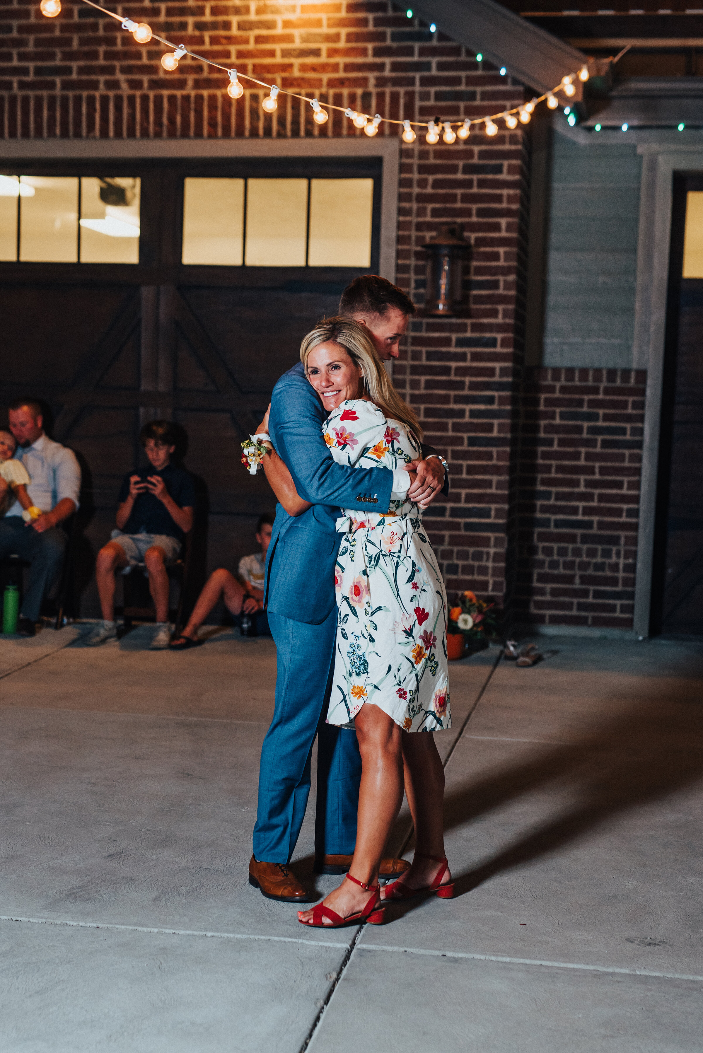  Mother of the groom dancing with her son at this dreamy backyard wedding in Park City. Kristi Alyse Photography Logan Utah photographer Park City wedding photographer Drive-Thru wedding COVID wedding neon signs socially distant wedding bride and gro