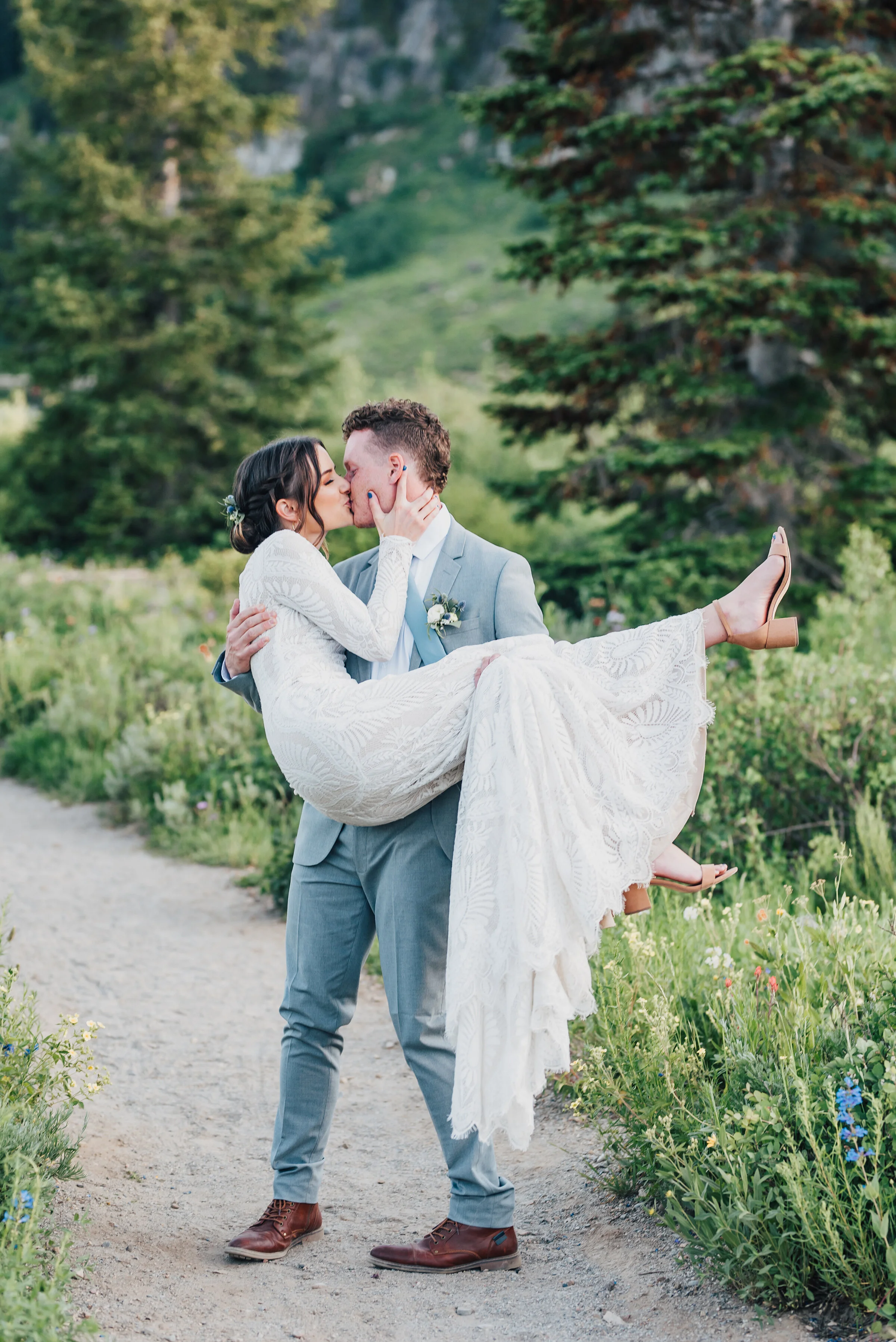  Dapper groom lifting and kissing his bride during their formals up Logan canyon at Tony Grove. Kristi Alyse photography Logan Utah wedding photographer forest nature dreamy formals Logan canyon Tony Grove scenic bridals Northern Utah photographer Ut
