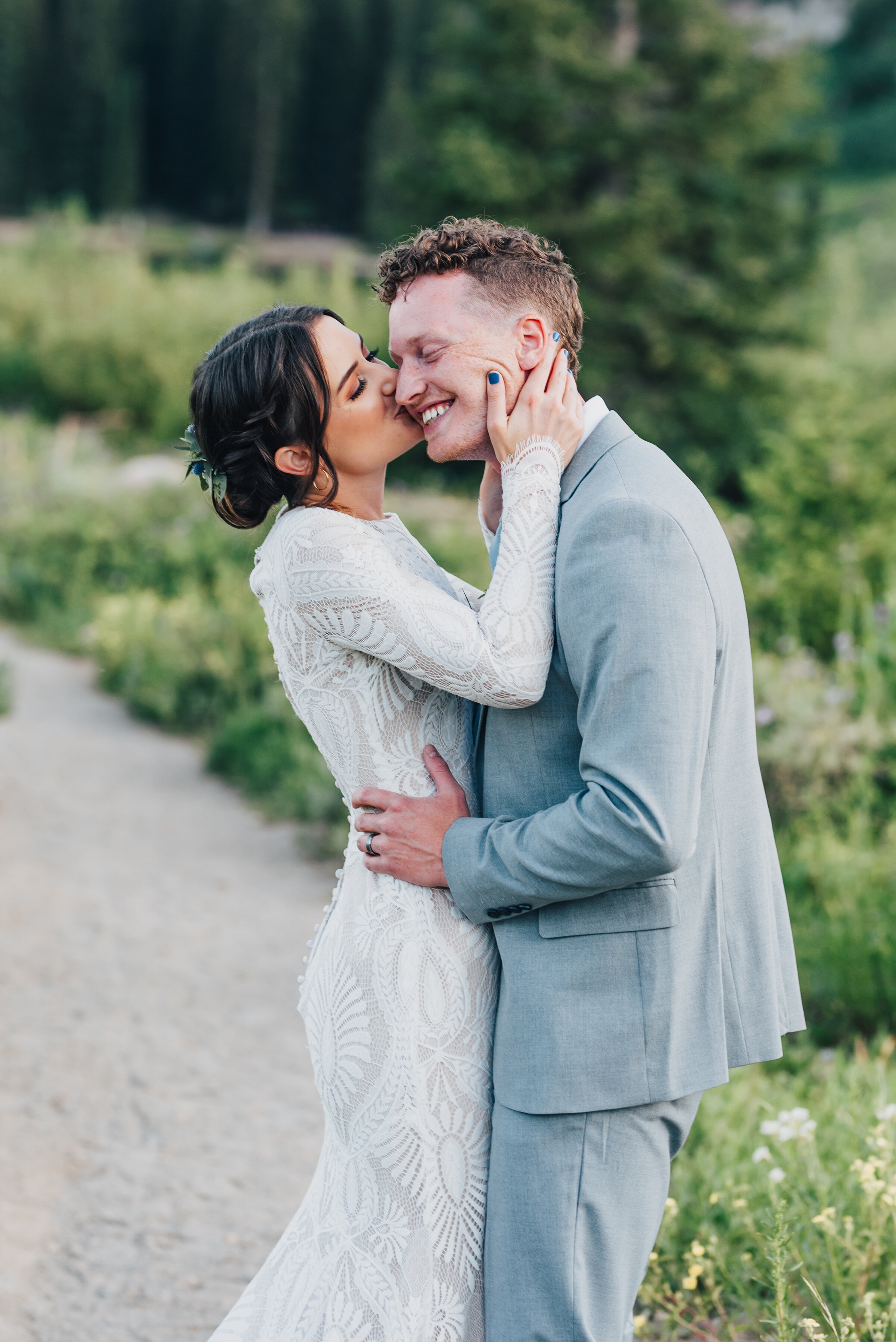  Bride planting kisses on her groom during their dreamy formals up Logan canyon at Tony Grove. Kristi Alyse photography Logan Utah wedding photographer forest nature dreamy formals Logan canyon Tony Grove scenic bridals Northern Utah photographer Uta