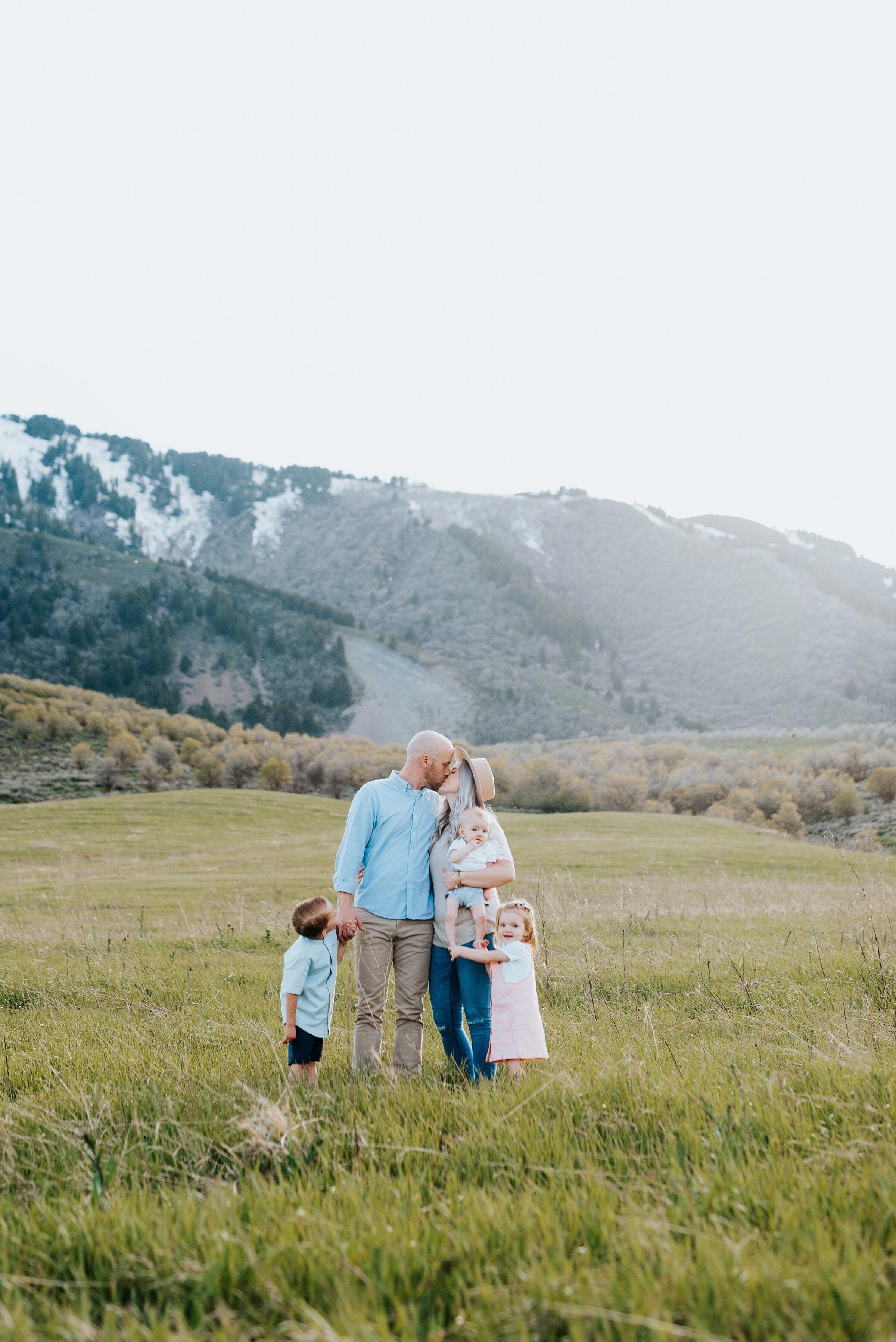  Wearing blue, pink, and cream the Homer family poses for a memorable mountain family photoshoot. Family photo ideas family outfit ideas family photo inspiration utah family photoshoot mountain color scheme matching family outfits pink and blue famil