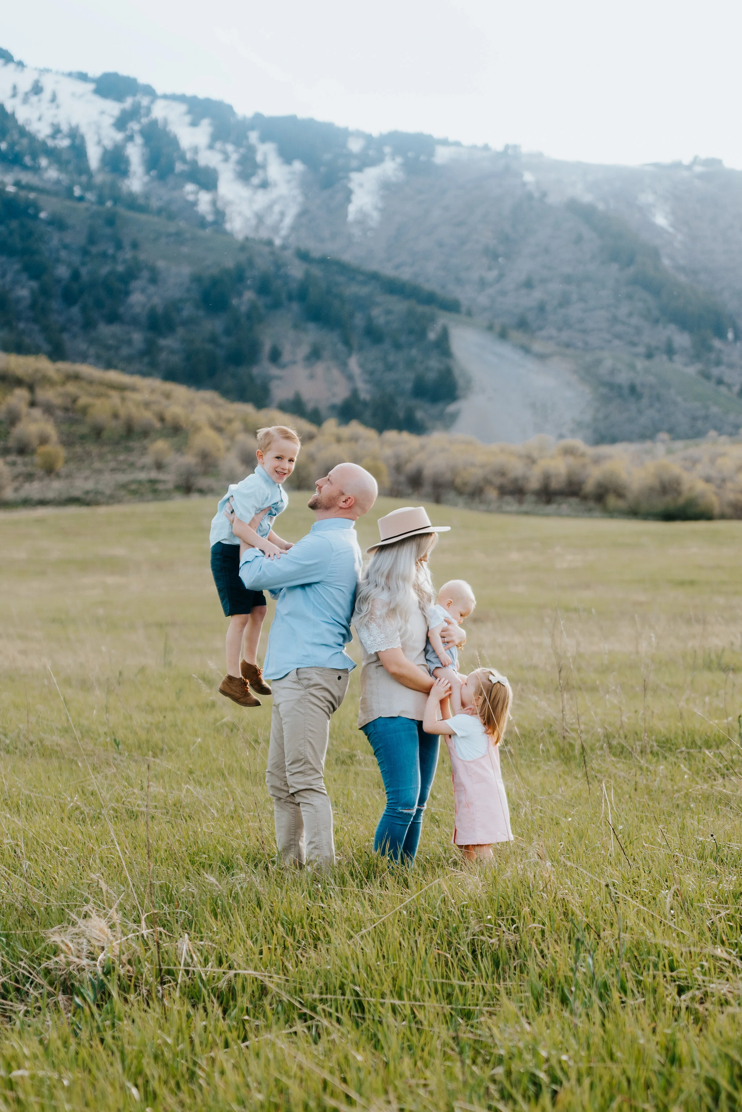  Dad holds son and mom holds daughter in precious family photo taken in the Wellsville Utah mountains. Family pose ideas for three children family pose ideas for mountain photoshoot logan utah photographer utah photographer capturing memories mama lo