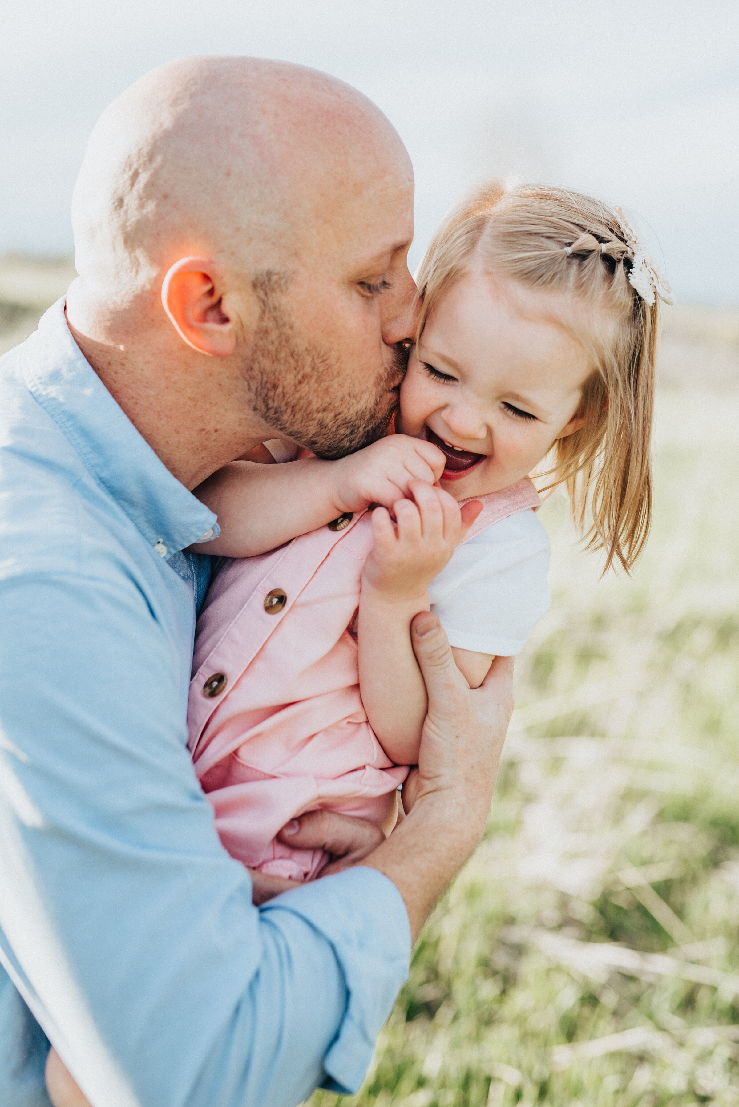  Happy father kisses his daughter's cheek during a mountain family portrait session. Logan utah photographer wellsville mountain families father and daughter photos family pose ideas family portraits utah photographer luxury family photoshoot #family