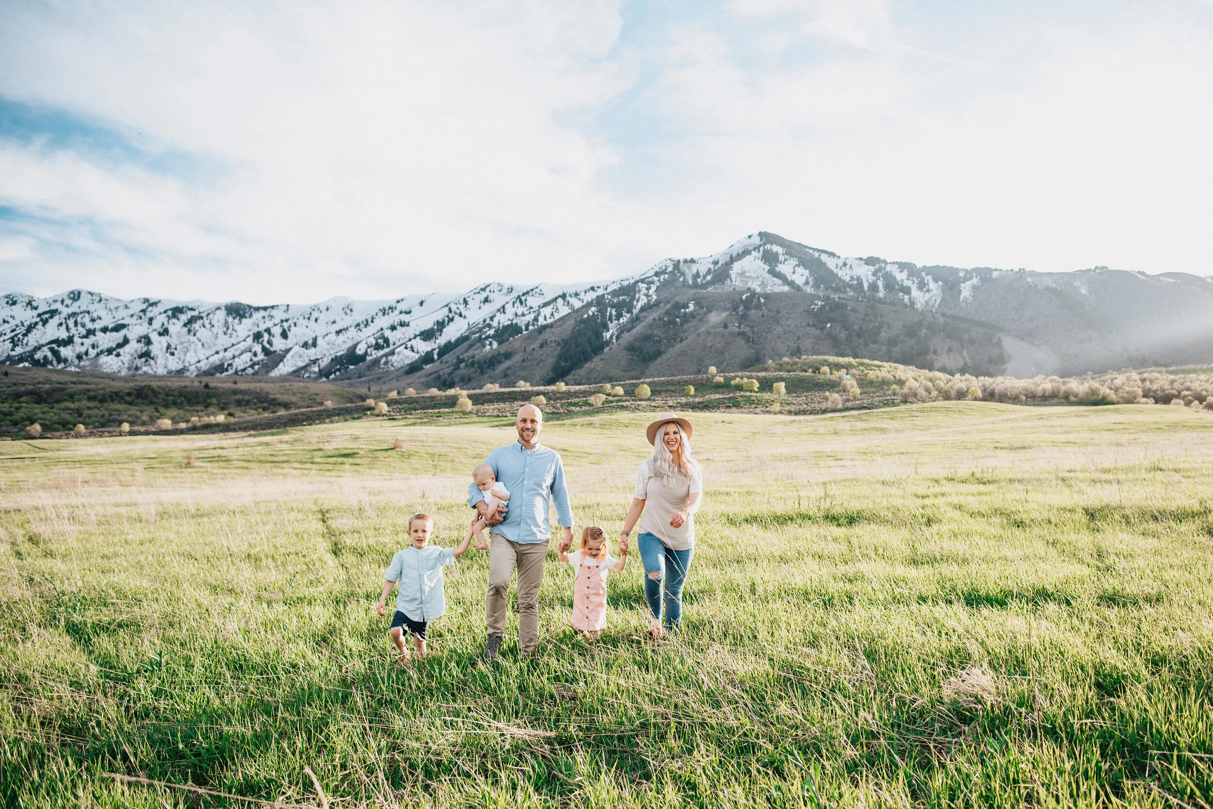  Family of five stands in the middle of a meadow in the wellsville mountains near logan utah. Happy family posing in mountain utah photography holding hands picture kristi alyse photographer family photography mountain family photography locations lo