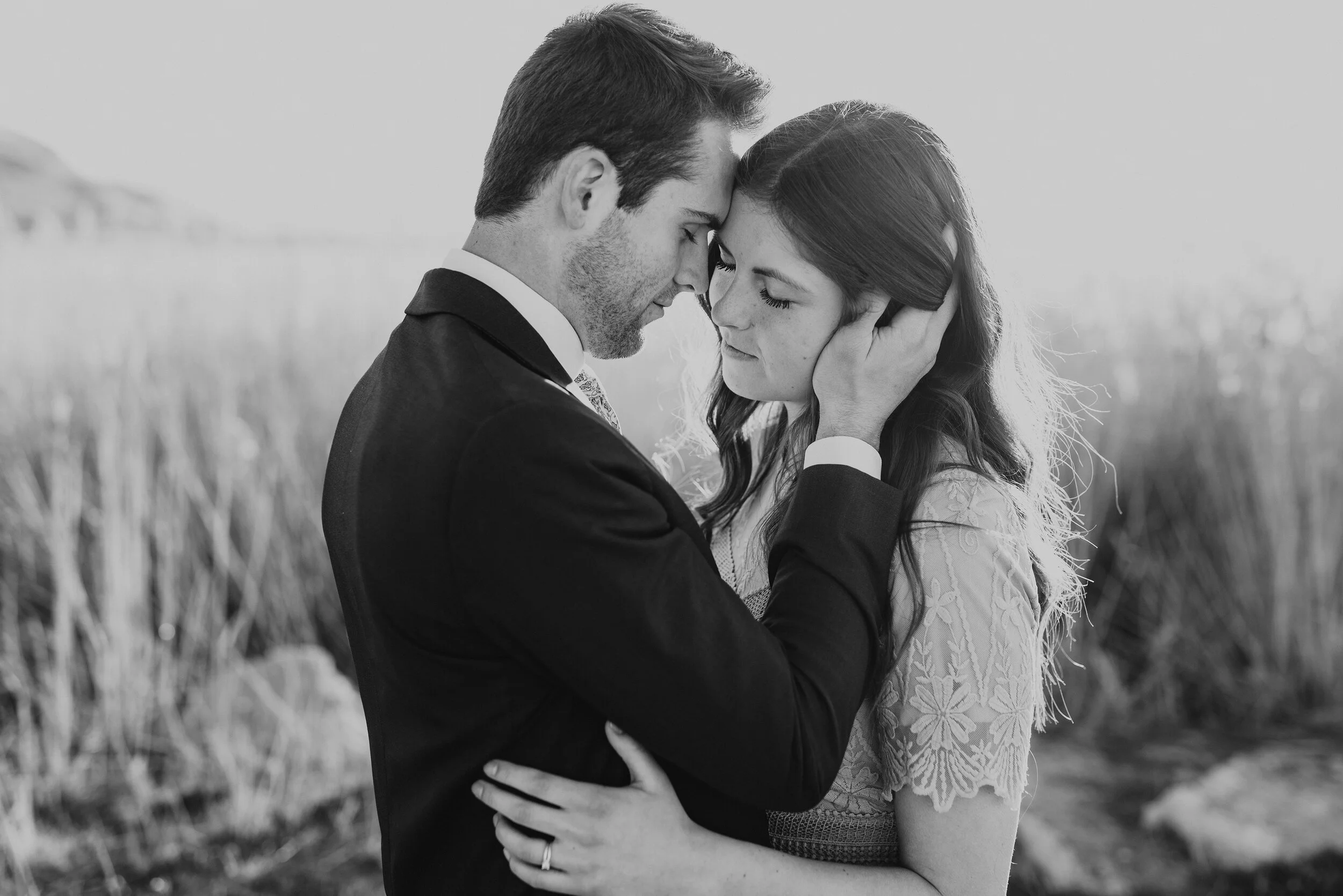 Black and white image of a couple almost embraces on the Salt Flats in Magna Utah during their engagement photography session. Black and white photography inspiration black and white engagement photoshoot nontraditional engagement poses Kristi Alyse…
