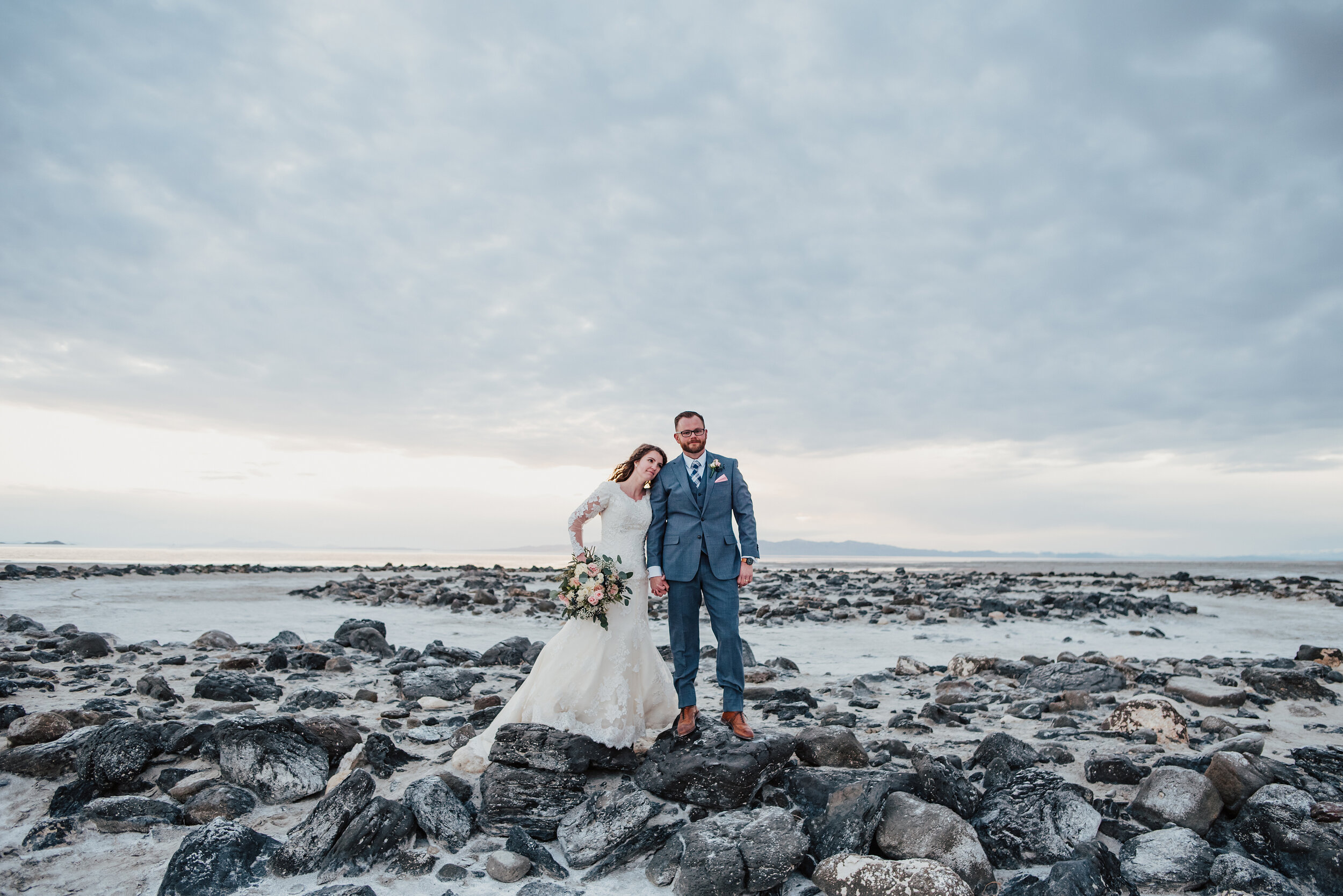  Standing on the rocks at the Spiral Jetty, this bride and groom took in all of the natural elements available during their wedding formal photoshoot. Spiral Jetty Northern Utah Great Salt Lake photography wedding formals natural photo aesthetic bride and groom #spiraljetty #utahphotography #weddingformals #gettingmarried #weddingattire #utahwedding #greatoutdoorswedding #weddingformalsphotoshoot #naturalbeauty 