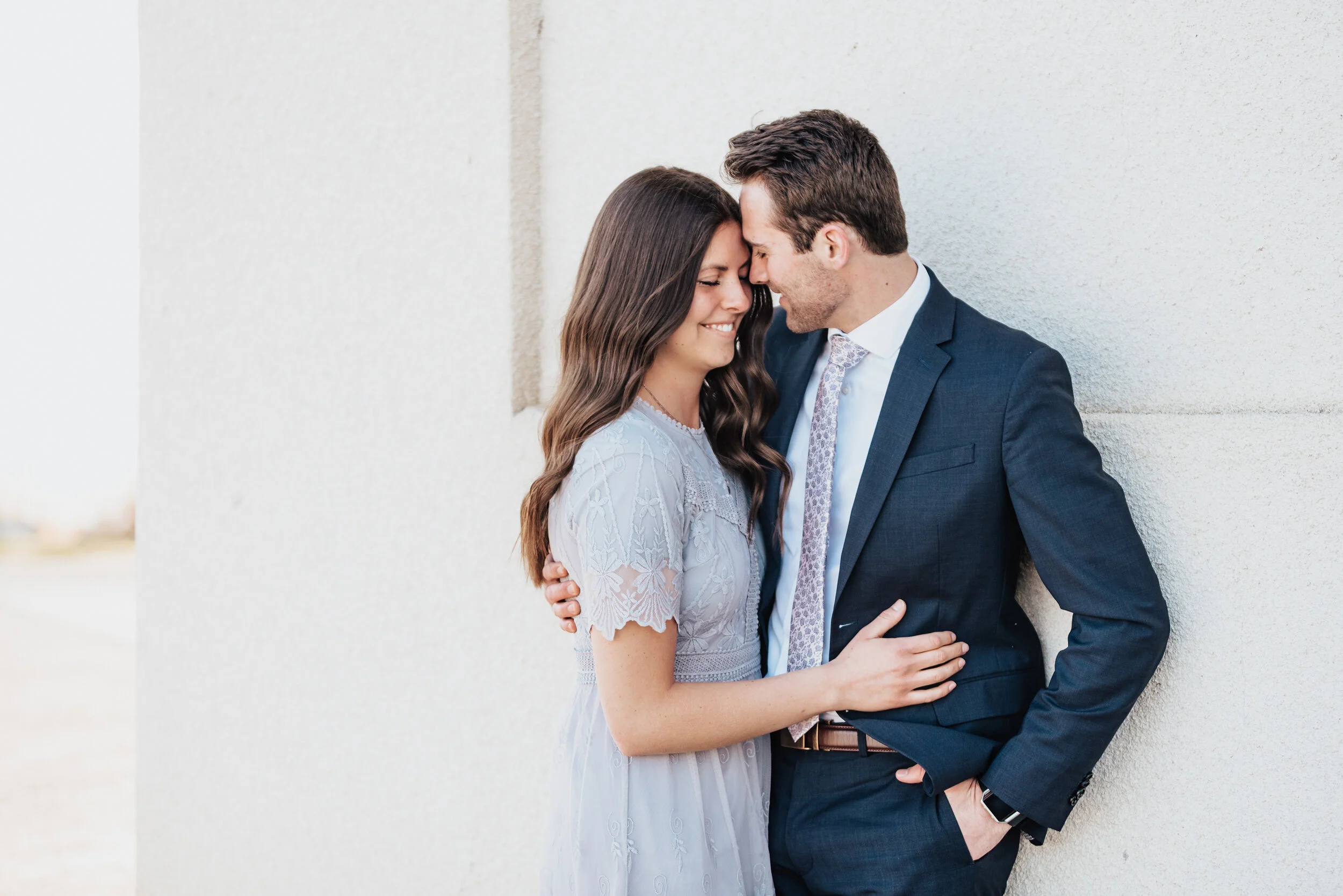  Couple looks across the salt flats in magna utah during their engagement photoshoot with Kristi Alyse Photography. Dry lake bed aesthetic magna utah photo locations outdoor nature engagement inspiration teal and coral matching outfits #kristialyseph