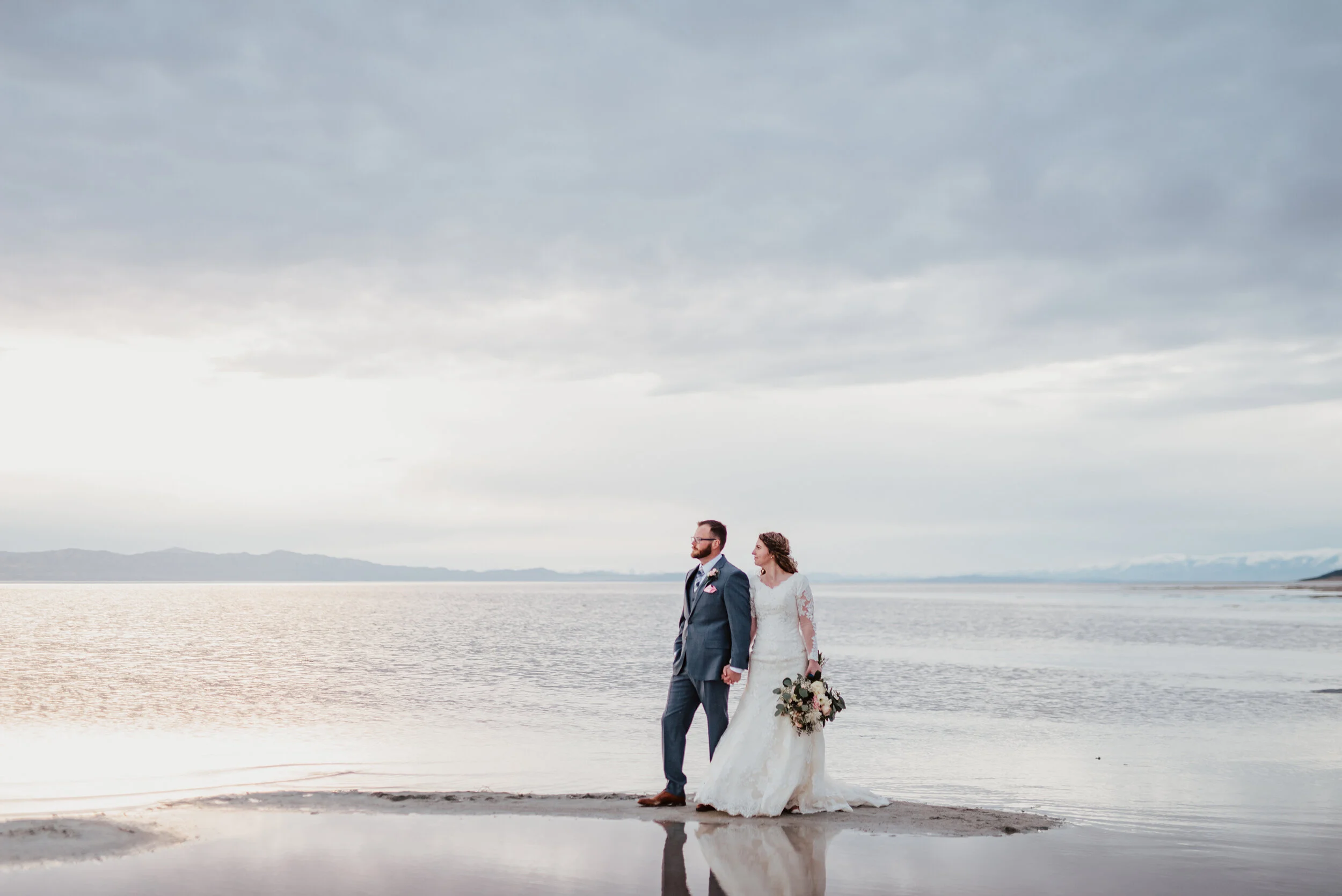  Walking along the sand as the sun set behind the Spiral Jetty near the Great Salt Lake. wedding formal photoshoot in Spiral Jetty Northern Utah Great Salt Lake photography wedding formals natural photo aesthetic bride and groom #spiraljetty #utahpho