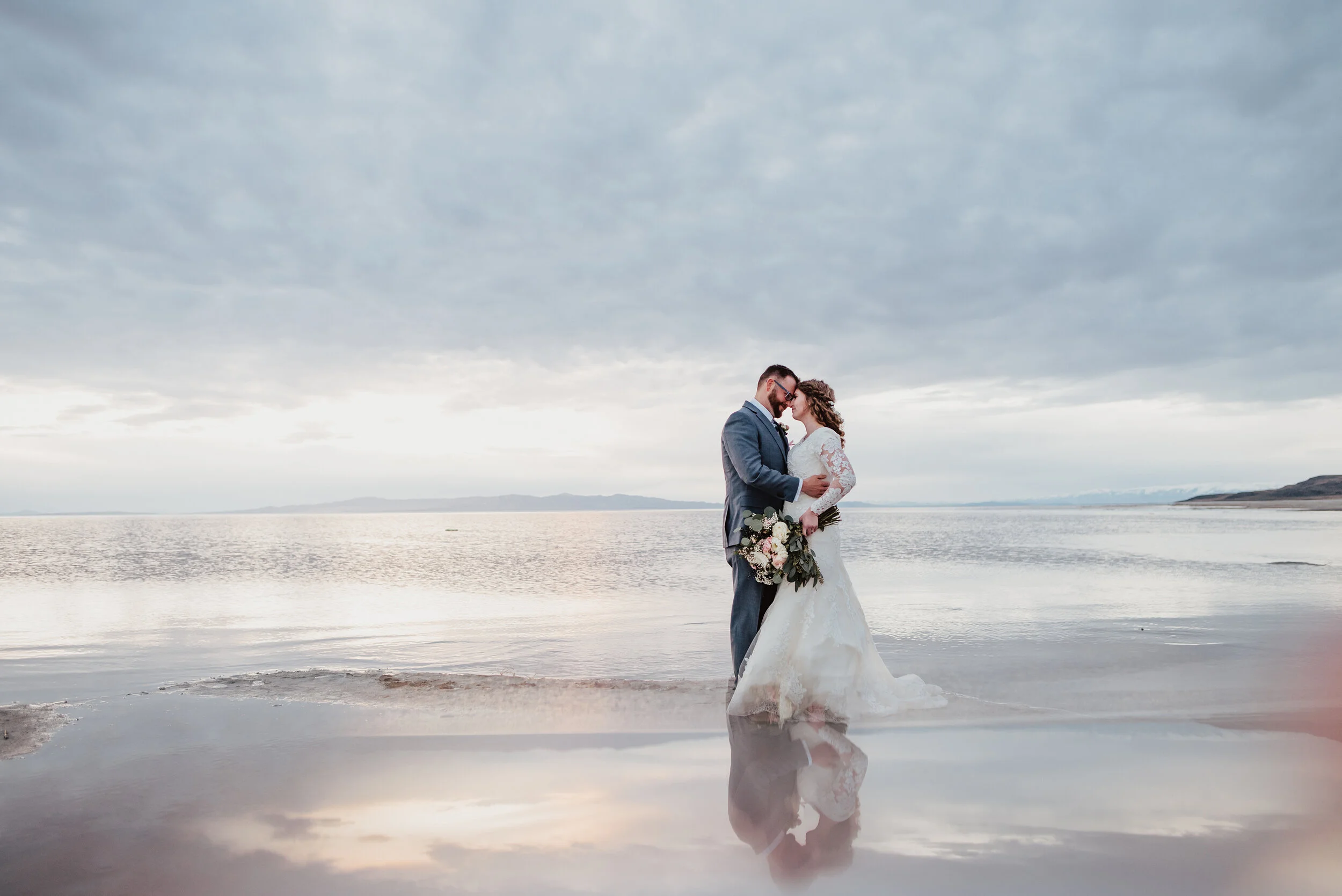 The Spiral Jetty in northern Utah is a location almost out of a fairytale as the sun sets and reflects off of the water onto this gorgeous bride and groom to be. wedding formal photoshoot in Spiral Jetty Northern Utah Great Salt Lake photography wed