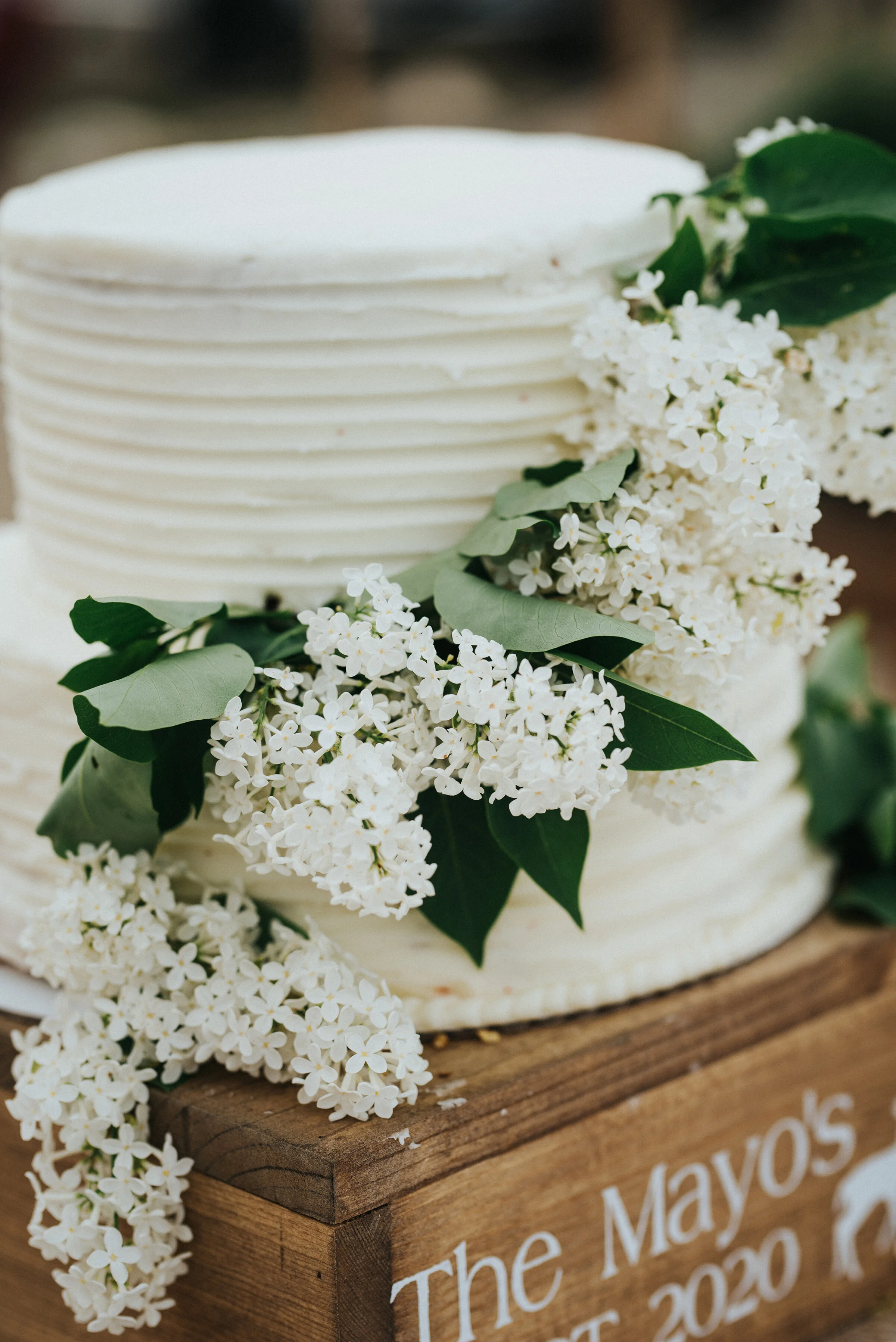  Simple and classic western wedding cake prepared for this bride and groom with white frosting and accented with white flowers and greenery. Wedding day photoshoot in Ephraim Utah photography wedding outdoor location western inspired rustic Airbnb ph