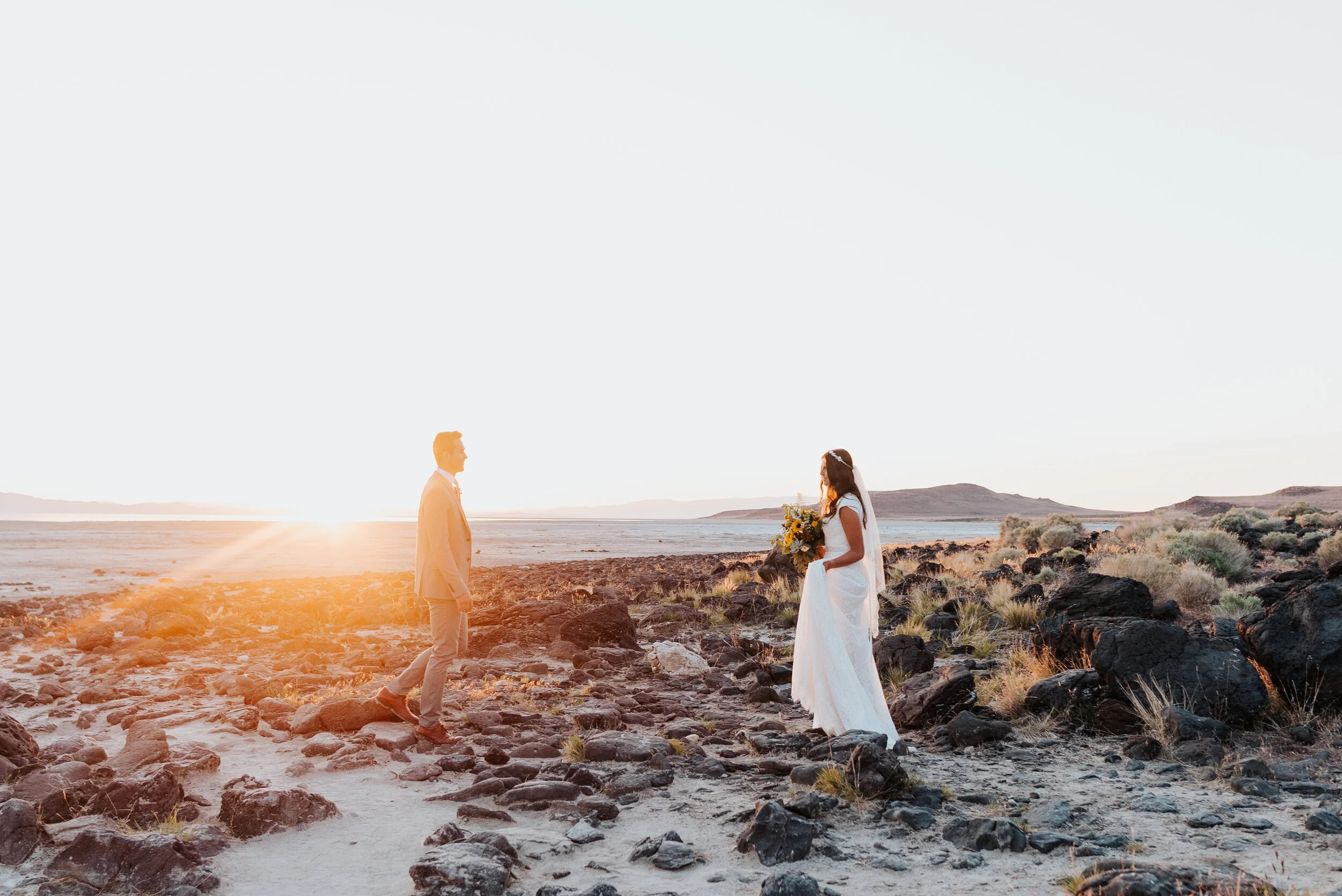Walking toward each other across the rocky shore of the Spiral Jetty, this bride and groom were thrilled to enjoy their formal session dressed in their wedding clothes in anticipation for their wedding day! #spiraljetty #GreatSaltLake #formalsession…
