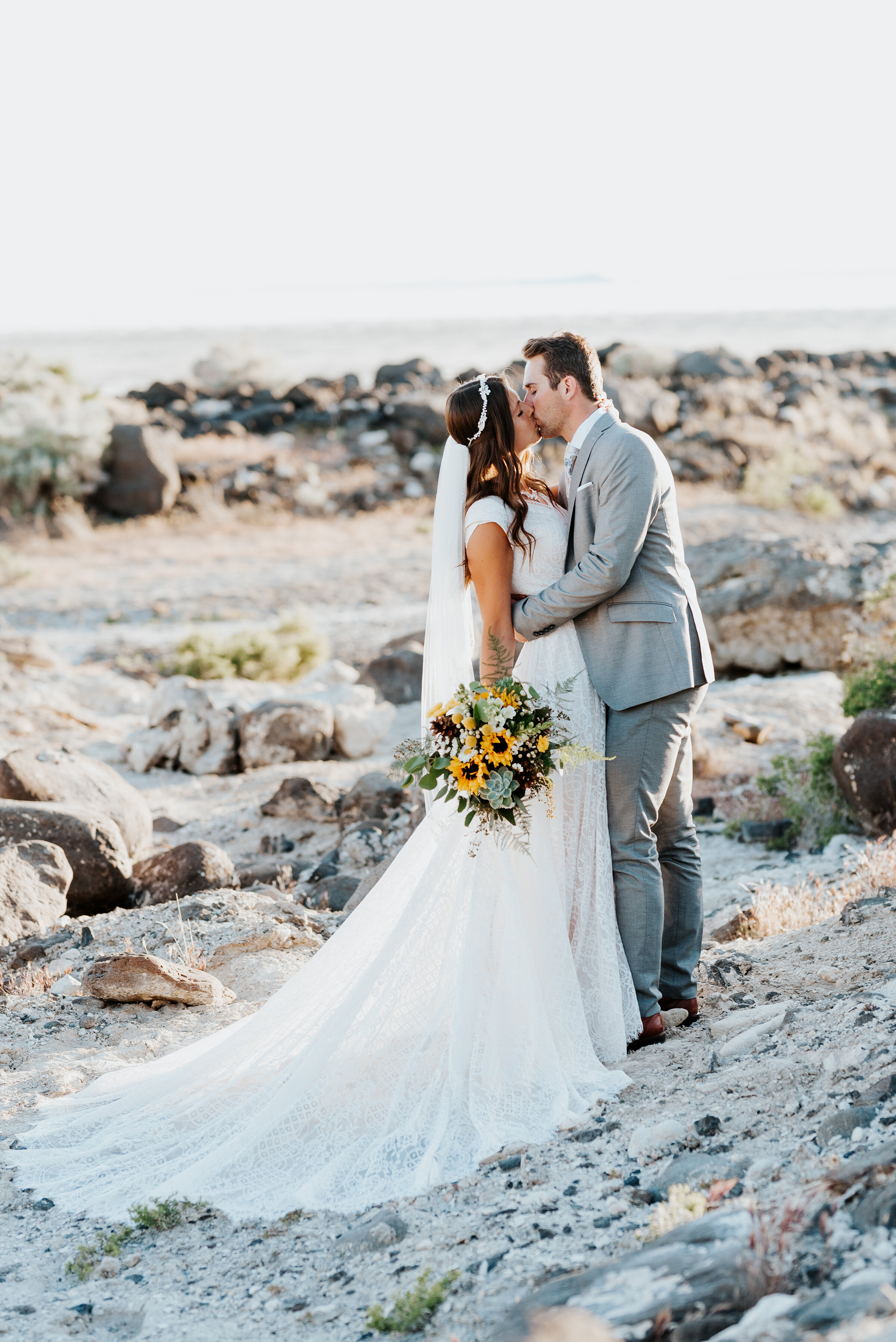  Bride and groom share an intimate kiss at their sunset session at the Great Salt Lake Spiral Jetty. sunflowers gorgeous rocky shore northern utah #spiraljetty #GreatSaltLake #formalsession #SaltFlats #sunsetphotosession #NorthernUtah #weddingphotogr