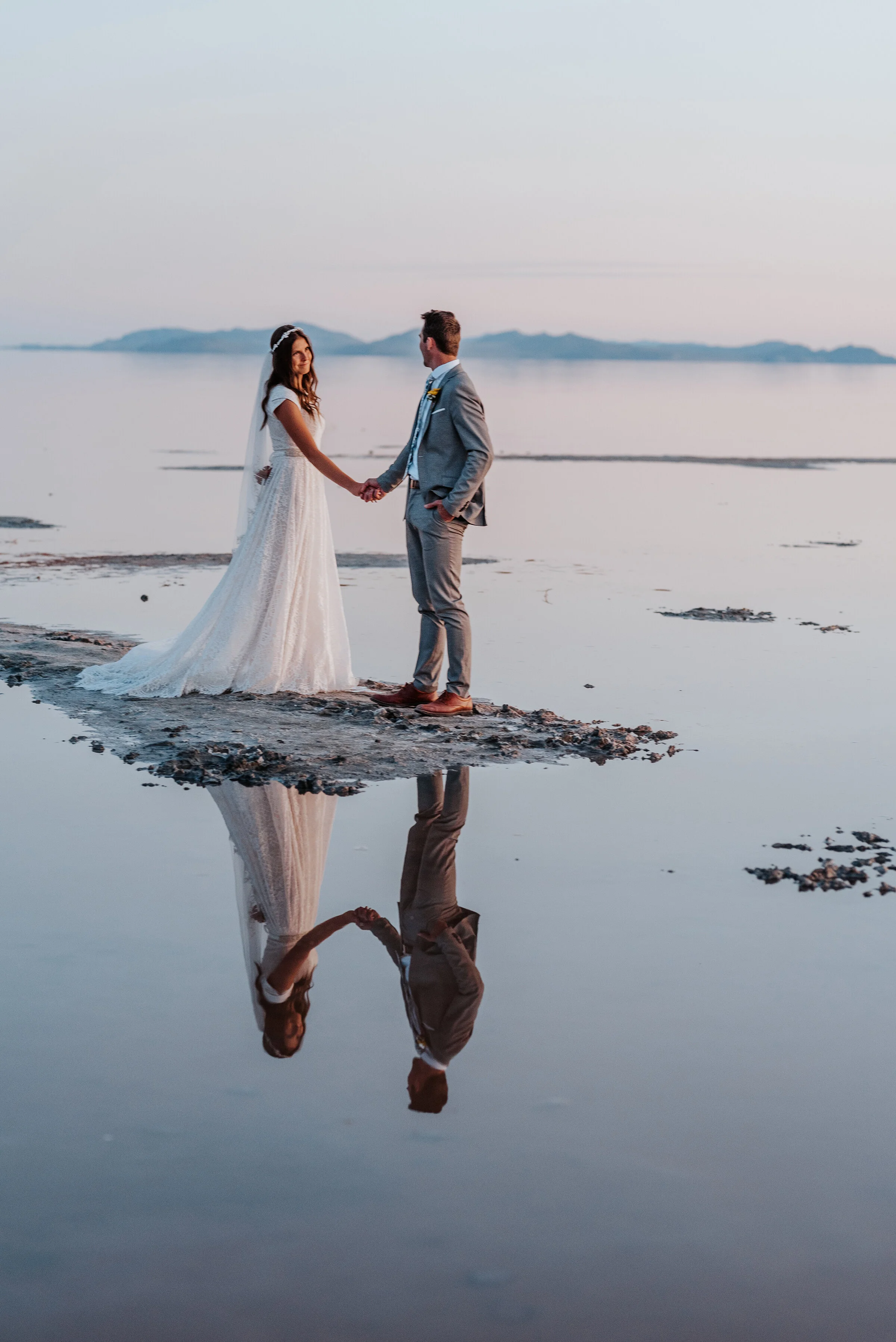  Flawless reflection of the bride and groom holding hands in the water of the Great Salt Lake Spiral Jetty. reflection water formal session sunset wedding photography #spiraljetty #GreatSaltLake #formalsession #SaltFlats #sunsetphotosession #Northern