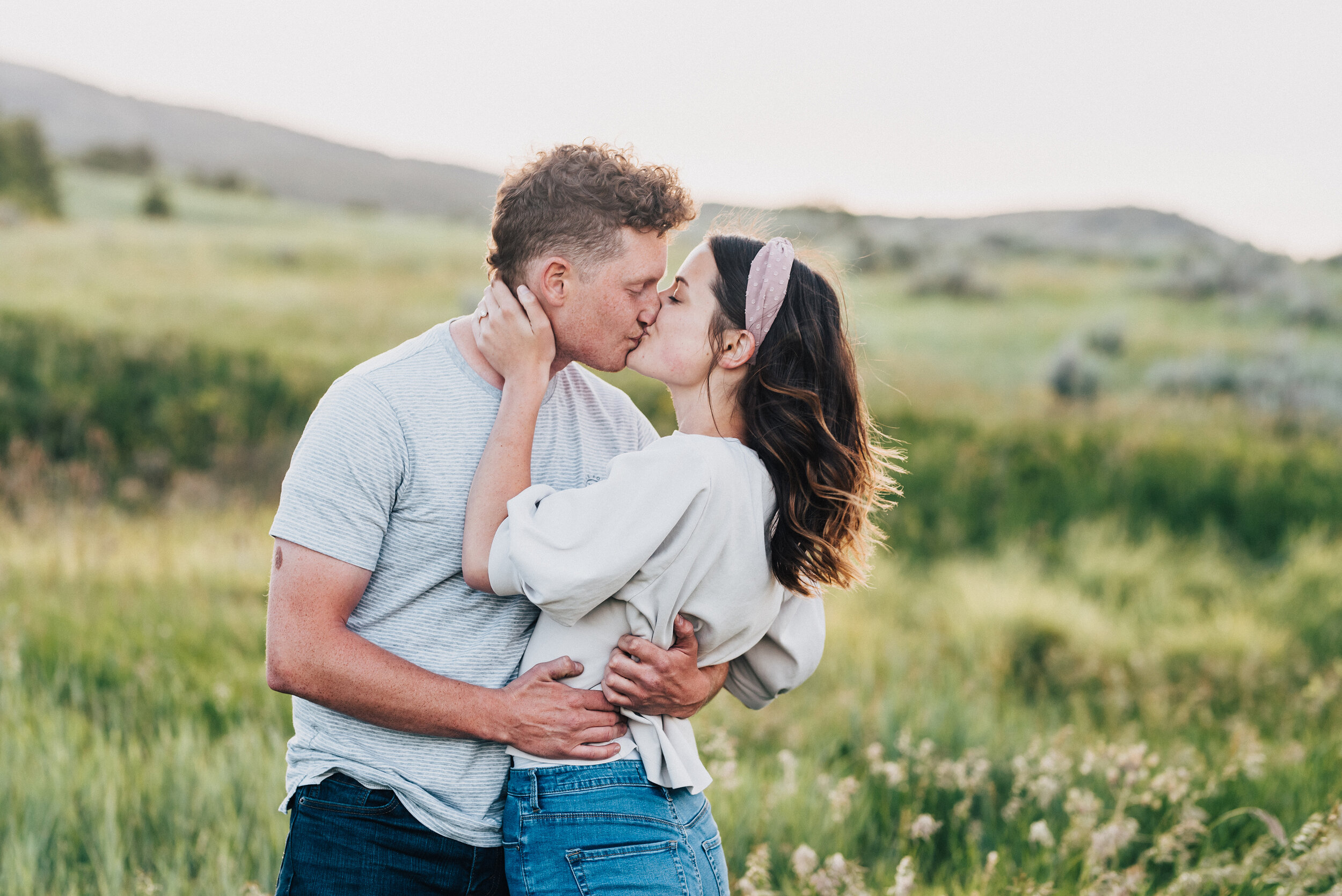 Kissing pose of the most adorable engaged couple by professional engagement photographer Kristi Alyse taken in Logan, Utah. Cache valley wedding photographer trendy outfits for engagements inspiration for couples session posing ideas outfit ideas pink headband kissing pose utah brides #engagements #couplespose #posingideas #weddingphotog #utahbride #professionalengagements #engagementinspo #couplesphotography #utahcouples #wellsville #mountainengagements