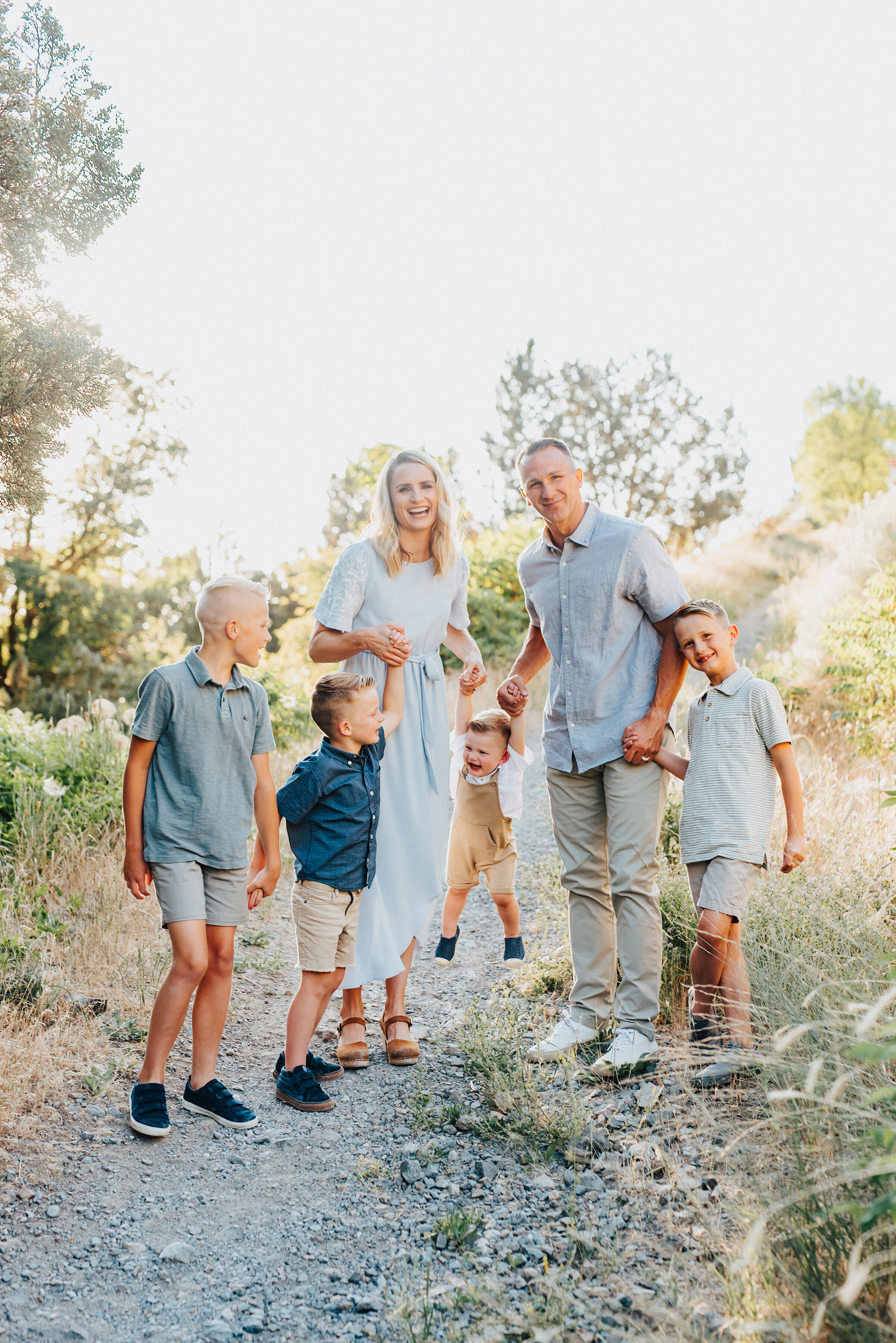  An adorable smiling family of six are holding hands while walking down a trodden footpath in Providence Canyon, UT. Light blue and khakis soft outdoor setting family photoshoot backlit sunlight in utah dessert #providencecanyon #utahphotography #utah #familyphoto #family #familyphotography #familyphotographer #photography #love #familytime #photooftheday #familyphotos #photographer #familylove 