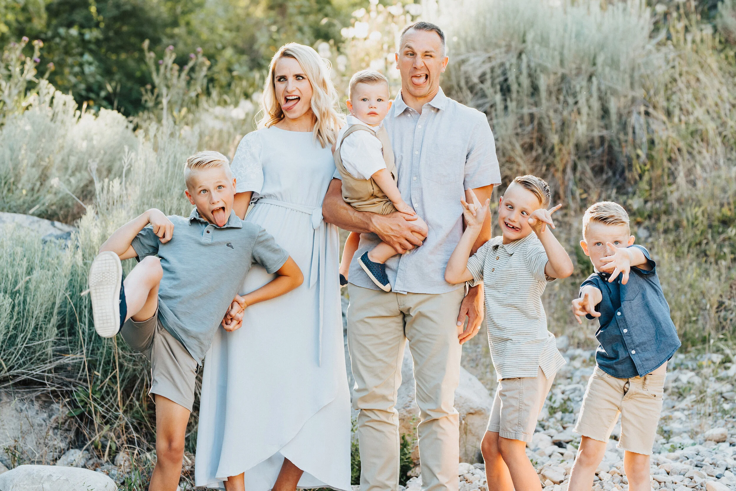 A goofy family strikes a silly pose while strolling through Providence Canyon in perfectly coordinated outfits. Light blue and khakis goofy positions smiling soft outdoor setting sunlit bakground #providencecanyon #utahphotography #utah #portrait #f…