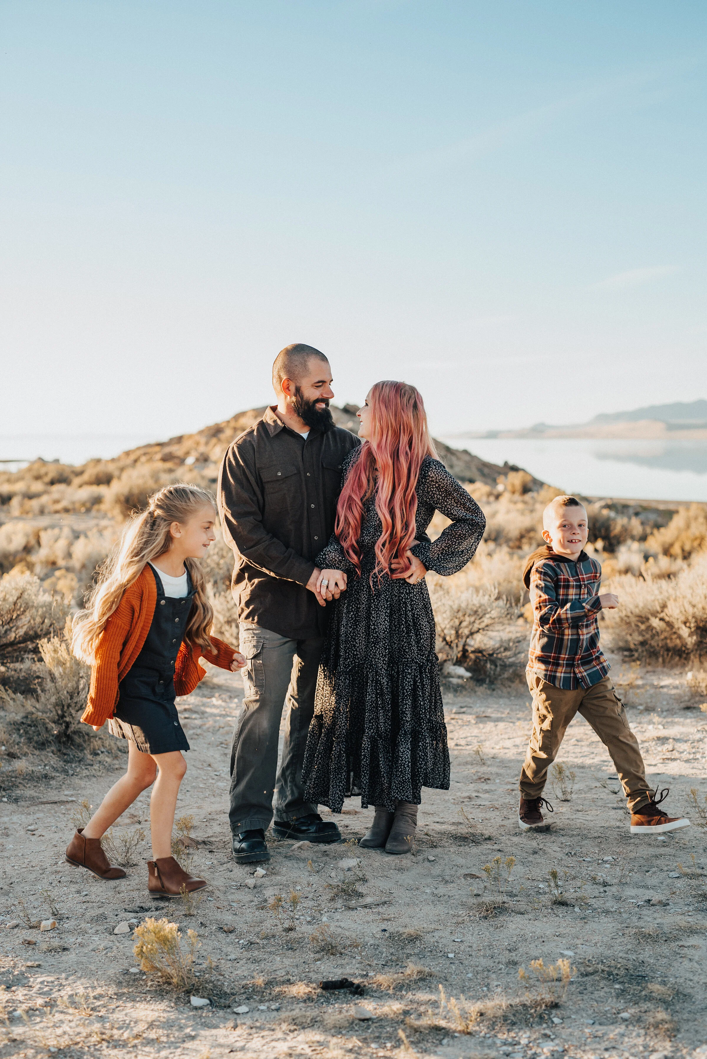  Family picture pose with mom and dad and daughter and son playing ring around the rosie by professional family photographer Kristi Alyse Photography in Salt Lake City, Utah. family pictures taken at antelope island family outfit inspiration for fall