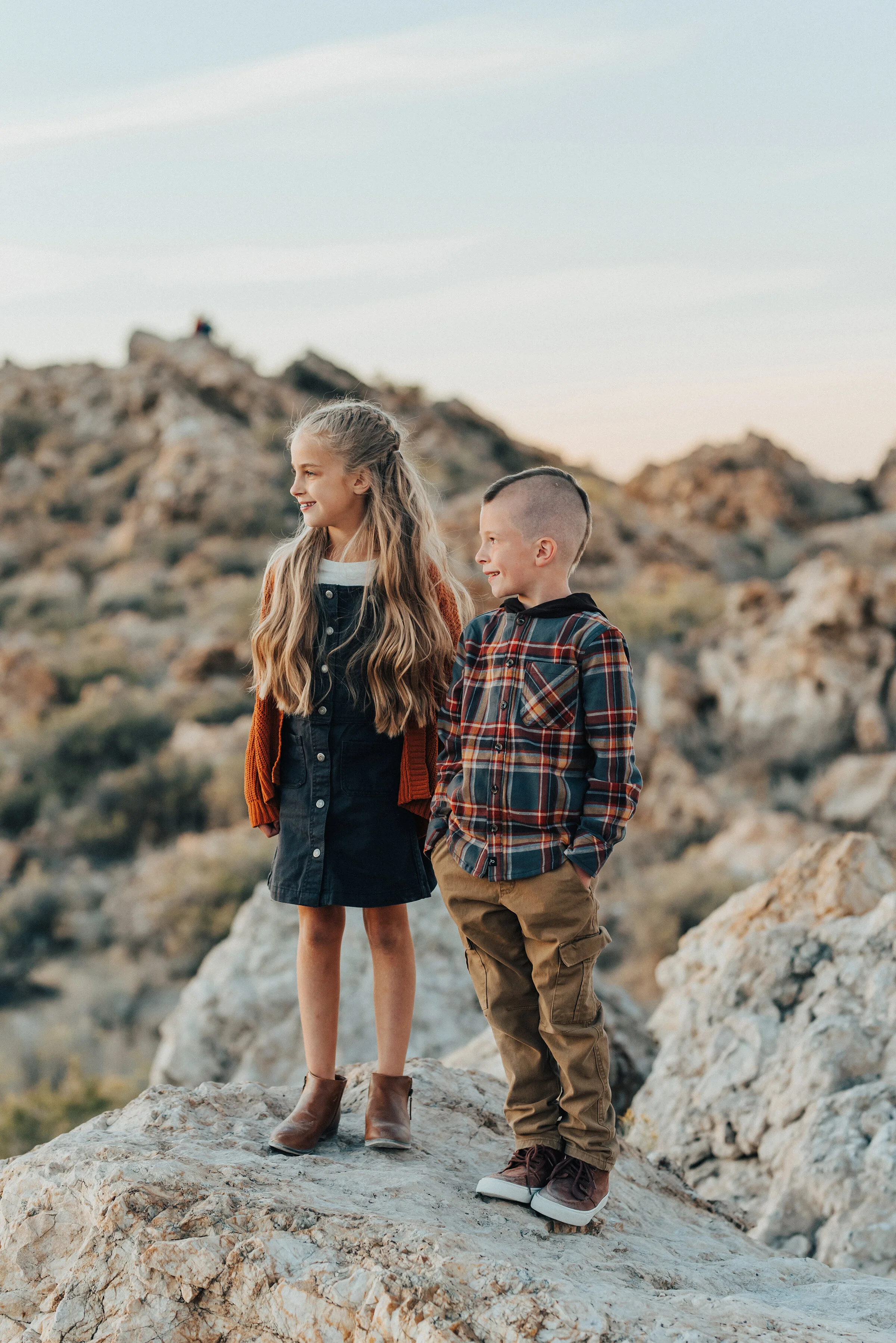  A beautiful sister stands with her younger brother stand on the rocks of Syracuse Utah in an Antelope Island family photo shoot. Kristi Alyse Photography sibling pose inspiration ideas and goals family photo shoot goals children outfit inspiration p