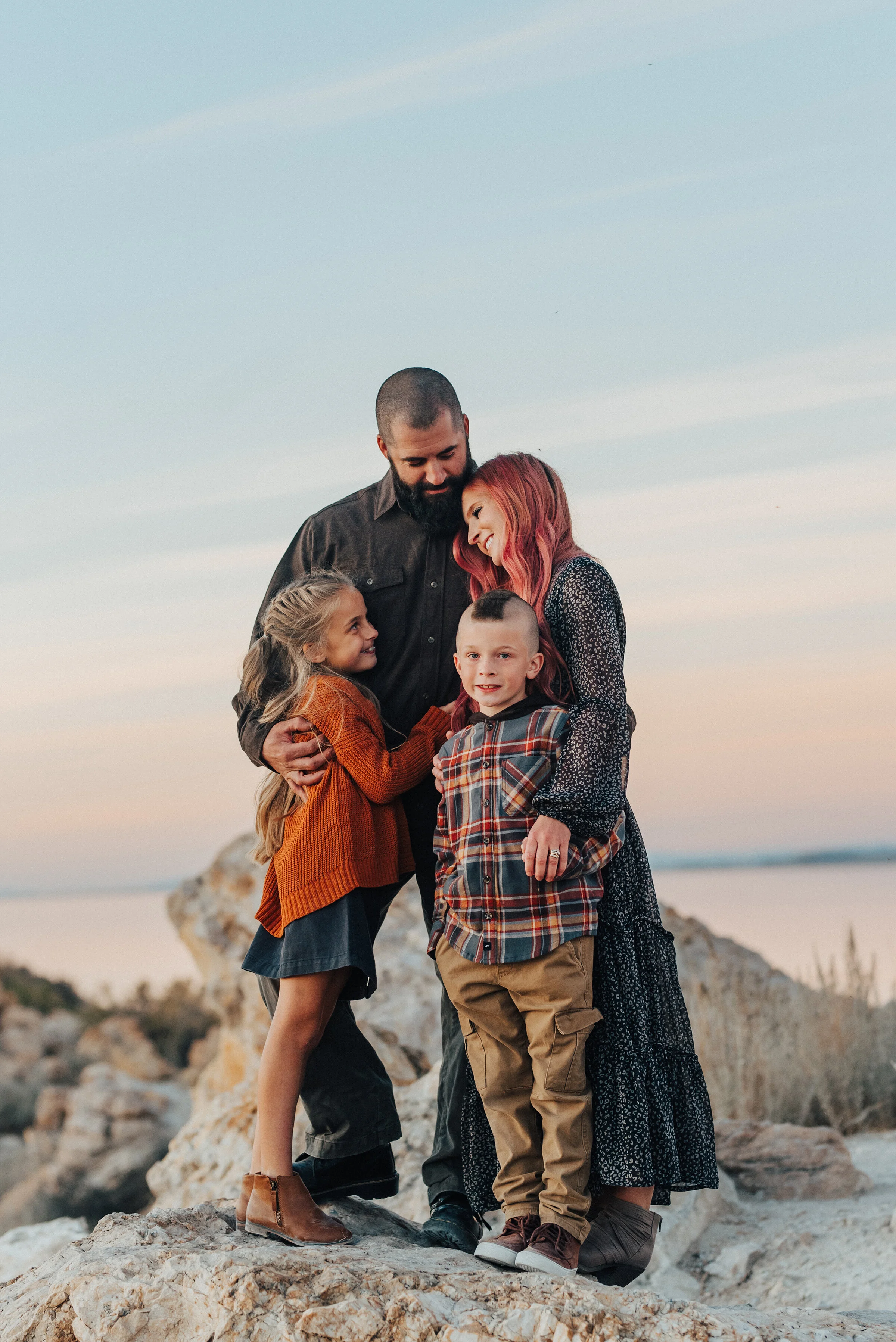  A sweet family hug each other in a beautiful and unique family photo shoot by Kristi Alyse Photography. Family pose goals ideas and inspiration family fall outfit inspiration family goals couple goals Utah family sunset photo shoot inspiration ideas