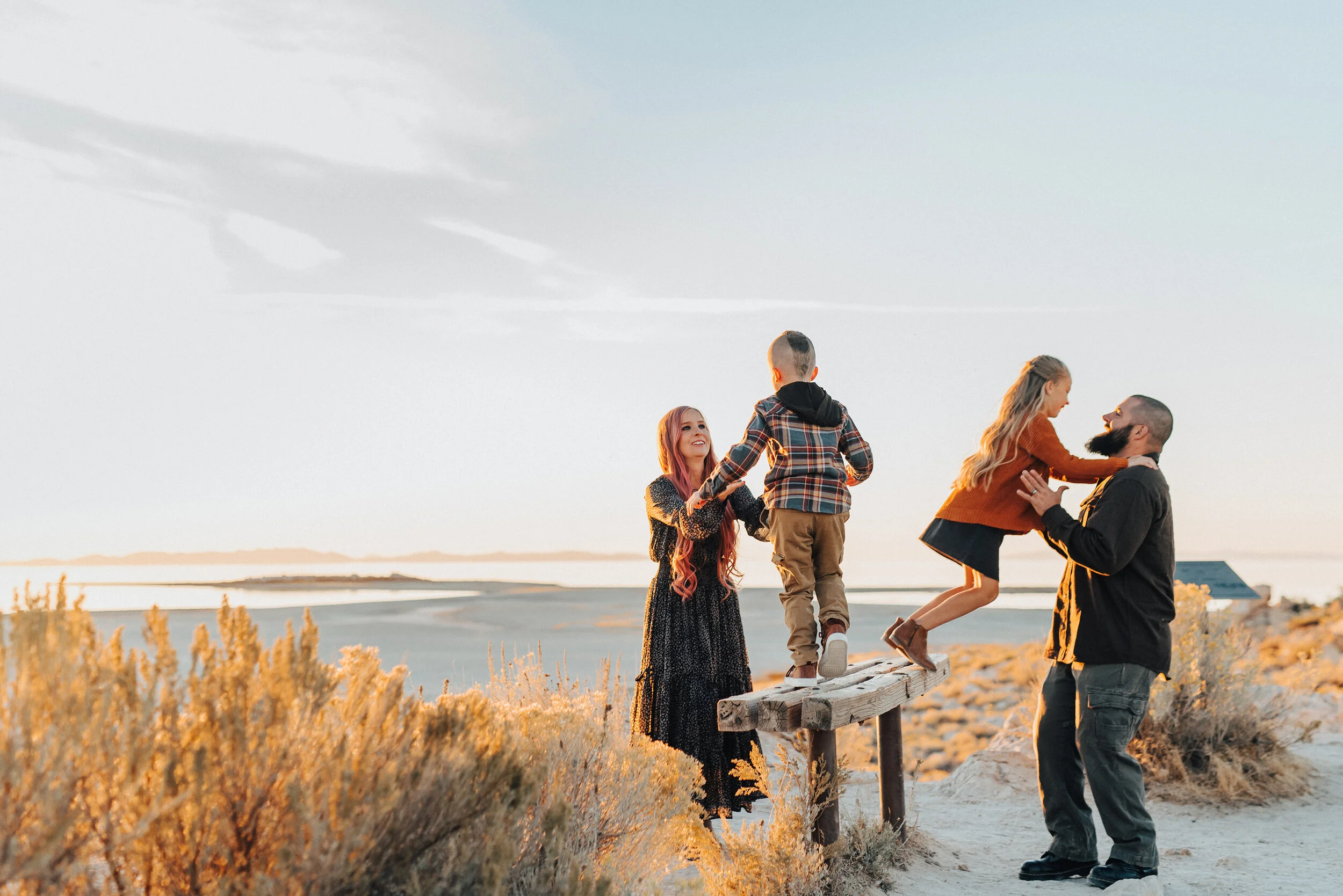 A sweet family play together on the beach of Antelope Island in Syracuse Utah. Professional family photographer Kristi Alyse Photography glowing family photo shoot inspiration family photo shoot goals playful family pose photo shoot fun young kids f…