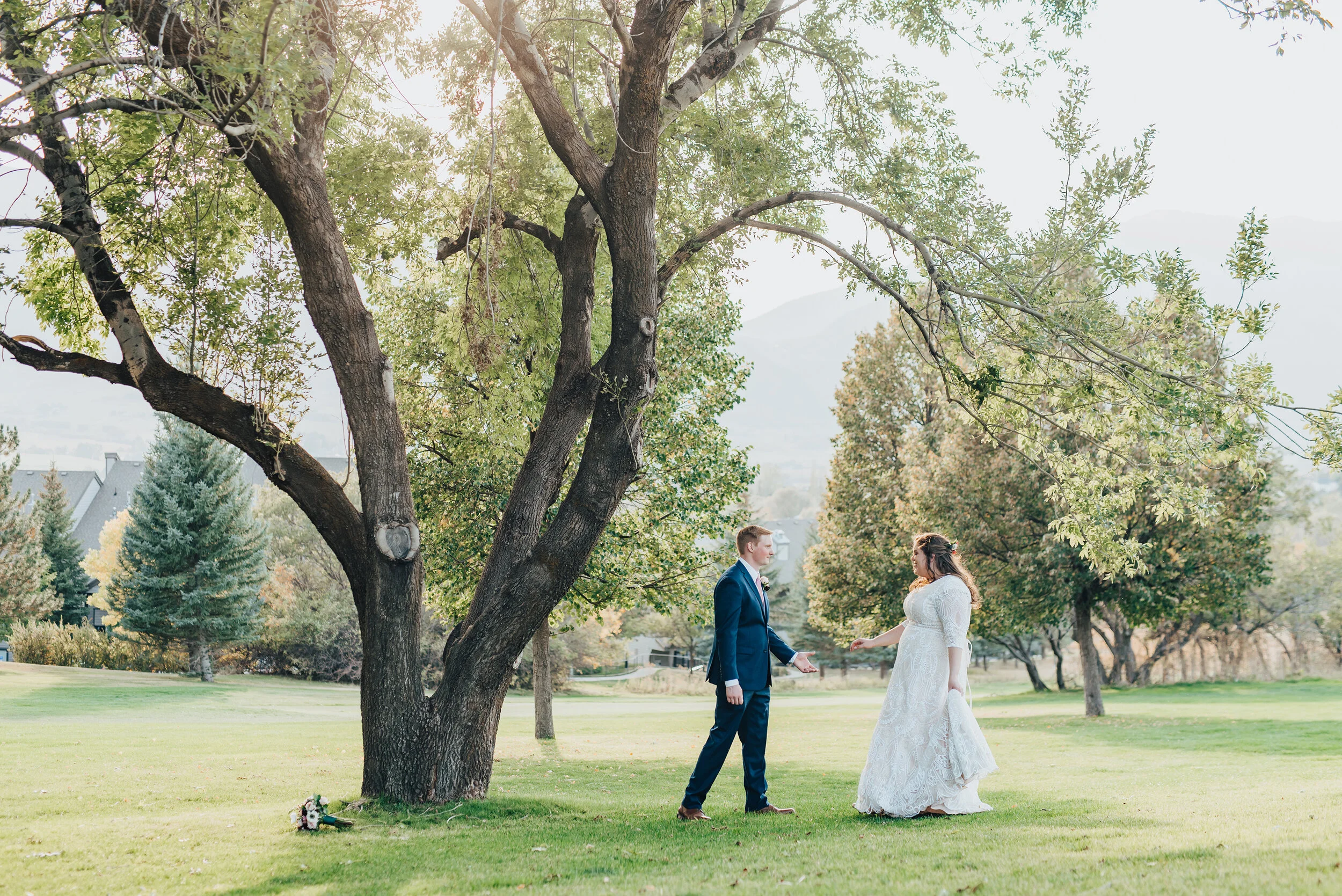 A shot of the bride and groom reaching for one another in Logan, Utah shot by Kristi Alyse Photography. Meaningful moments in northern Utah photography Kristi Alyse green trees bride and groom photo floral bouquet wedding hairstyle inspo #weddingins…