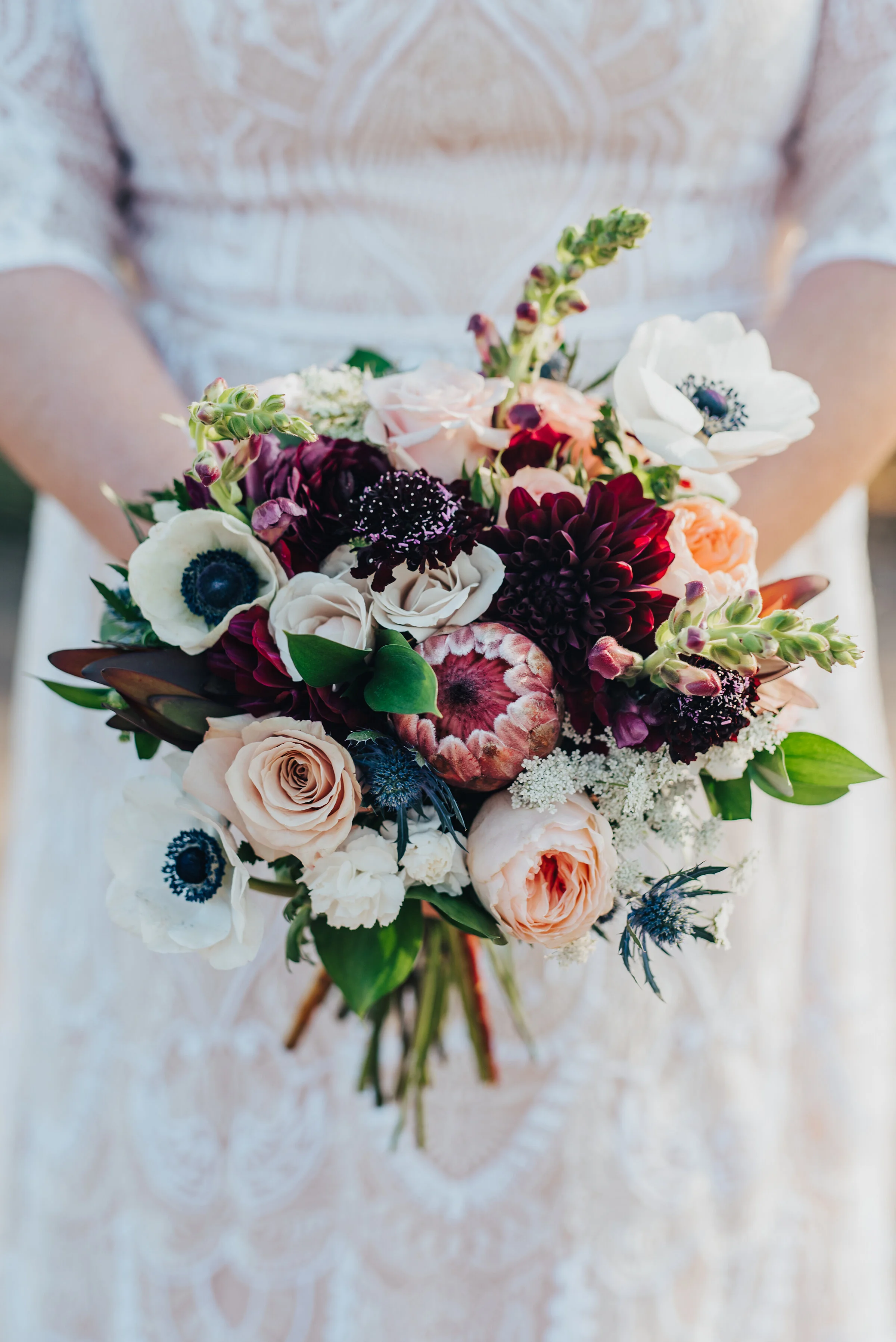 Stunningly detailed shot of the gorgeous brides flower bouquet in Logan, Utah by Kristi Alyse Photography. Brides bouquet of colorful flowers inspo wedding day floral arrangement lace wedding dress meaningful details unique photography northern Loga…