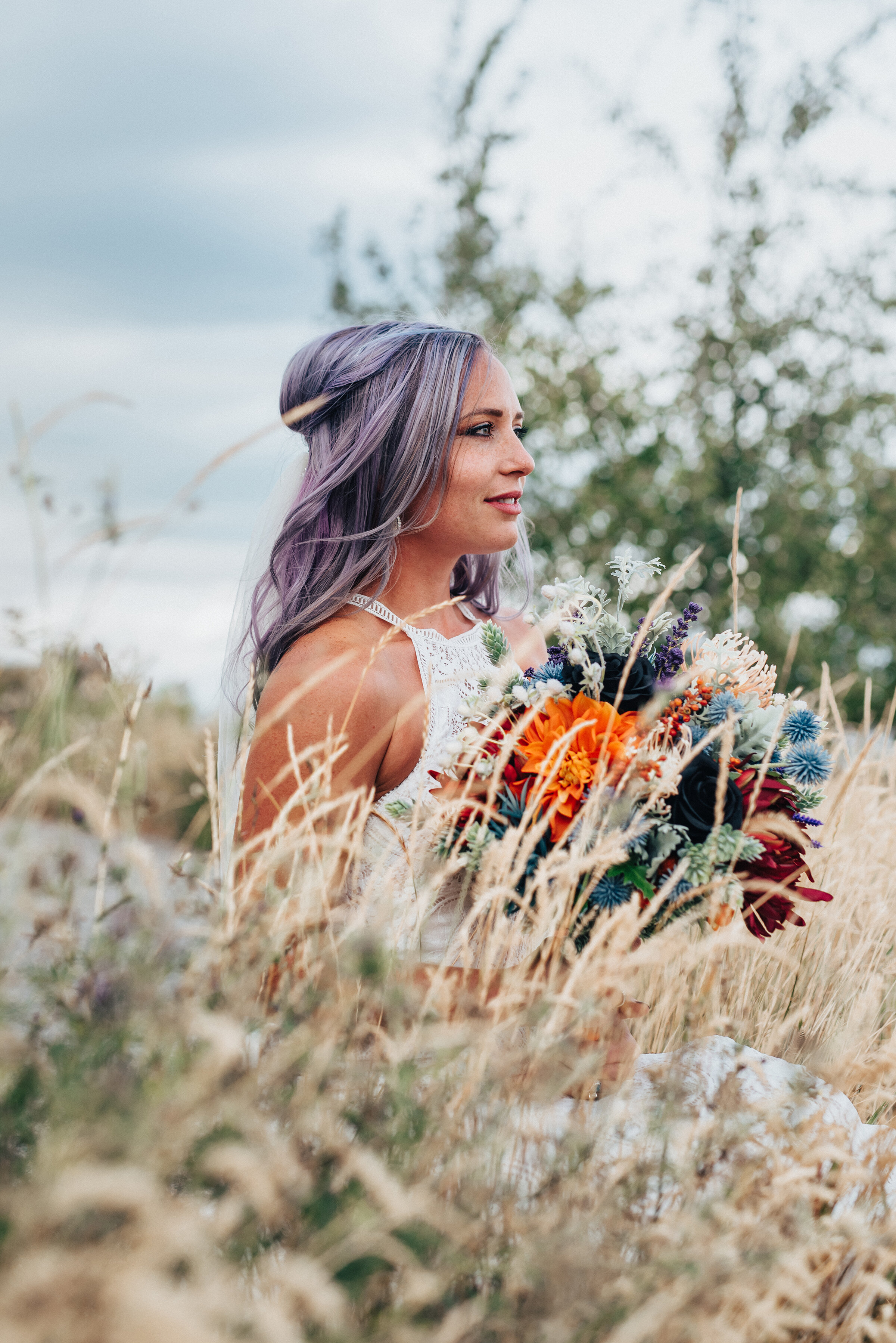  Beautiful bride with purple hair and high neck lace dress with purple and orange wedding flowers in this boho styled shoot by Kristi Alyse Photography in Northern Utah. logan utah wedding and family photographer boho wedding quality photography mean