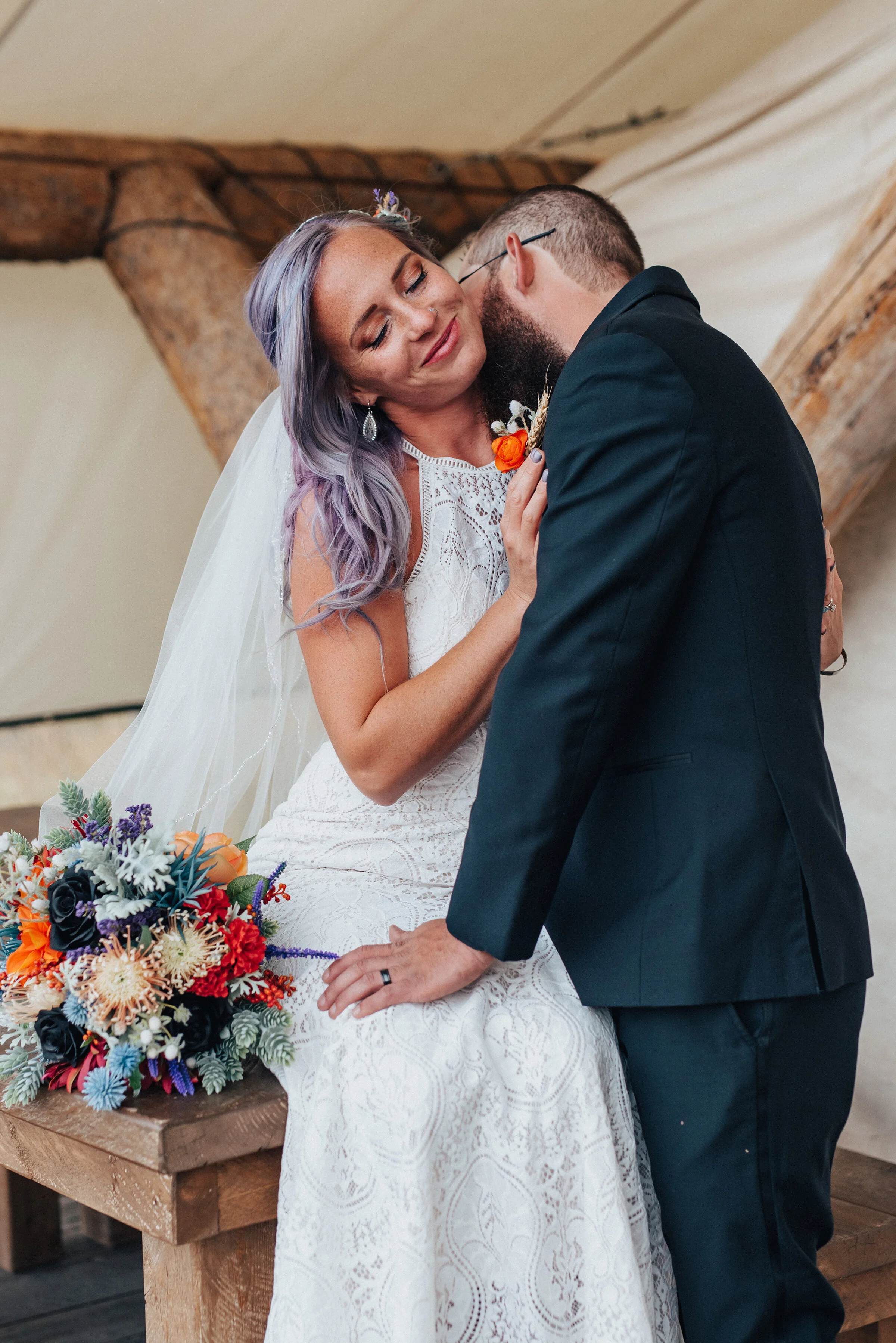 Groom and bride with orange purple and blue wedding bouquet with lace dress and black suit in this boho styled shoot by Kristi Alyse Photography in Northern Utah. logan utah quality photography meaningful photography wedding and family photographer …
