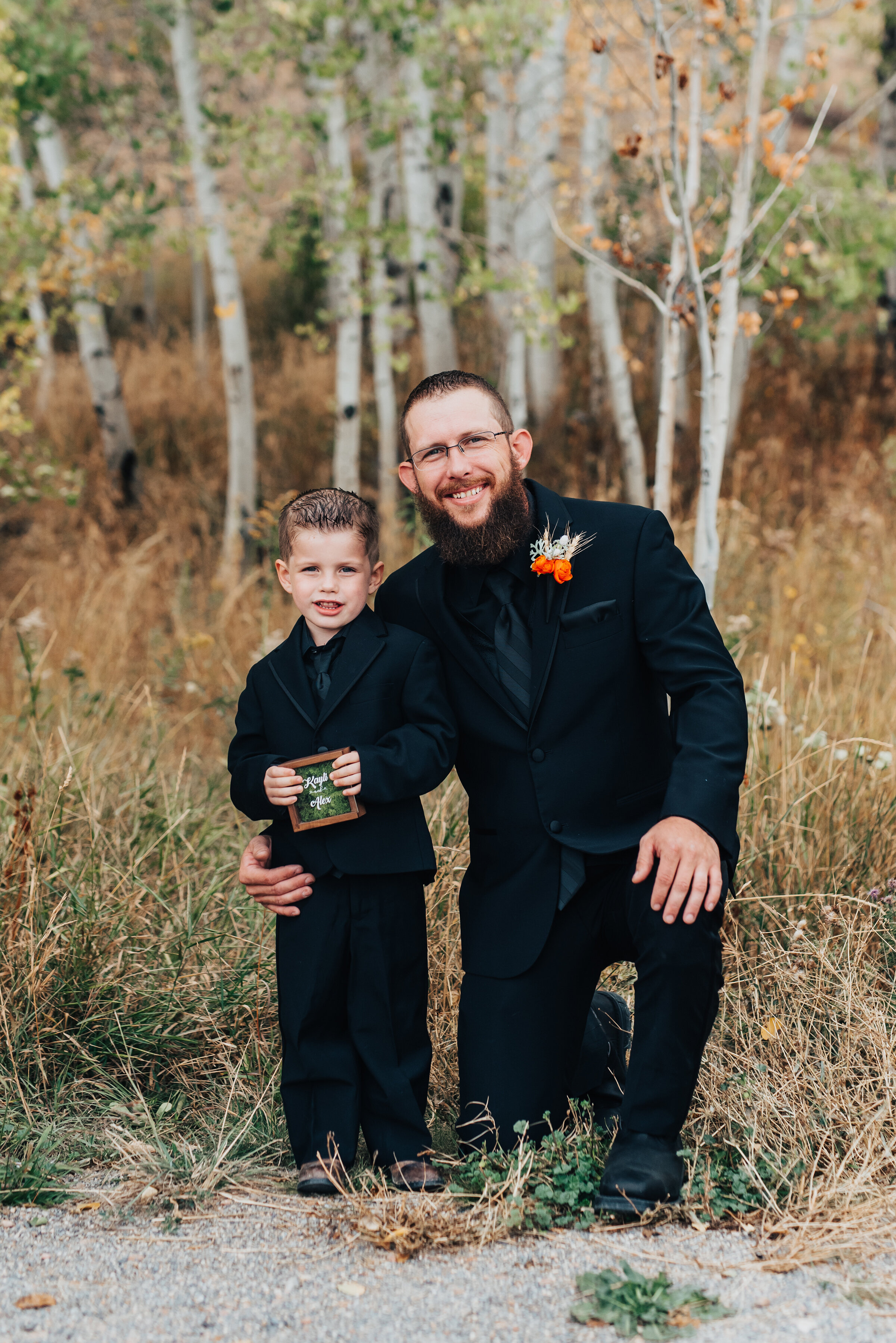  Groom and child in matching black suits with orange boutonniere in this fall styled wedding shoot by Kristi Alyse Photography in Logan Utah. father son matching black suits orange boutonniere fall wedding logan utah quality photography meaningful ph