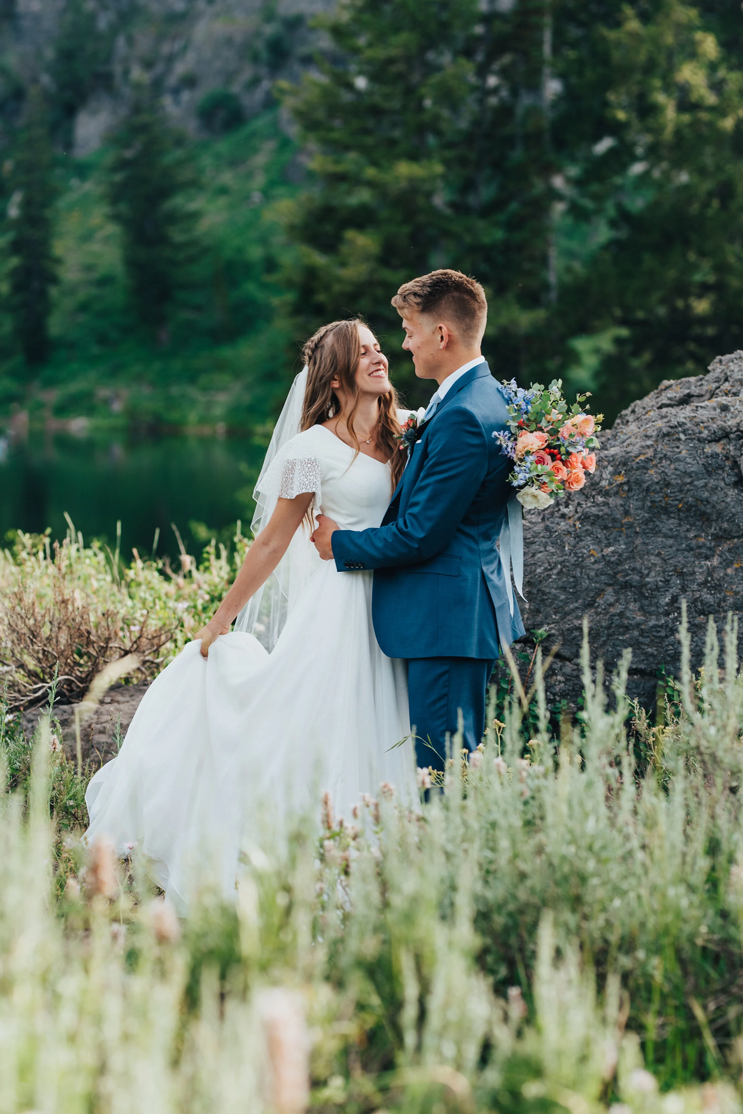  Gorgeous wedding formals of a modest bride and a groom in a blue suit set against the pine trees of Tony Grove. Utah wedding formals at Tony Grove wedding bridals in the mountains pine tree wedding photography adventurous bride to be wedding plannin