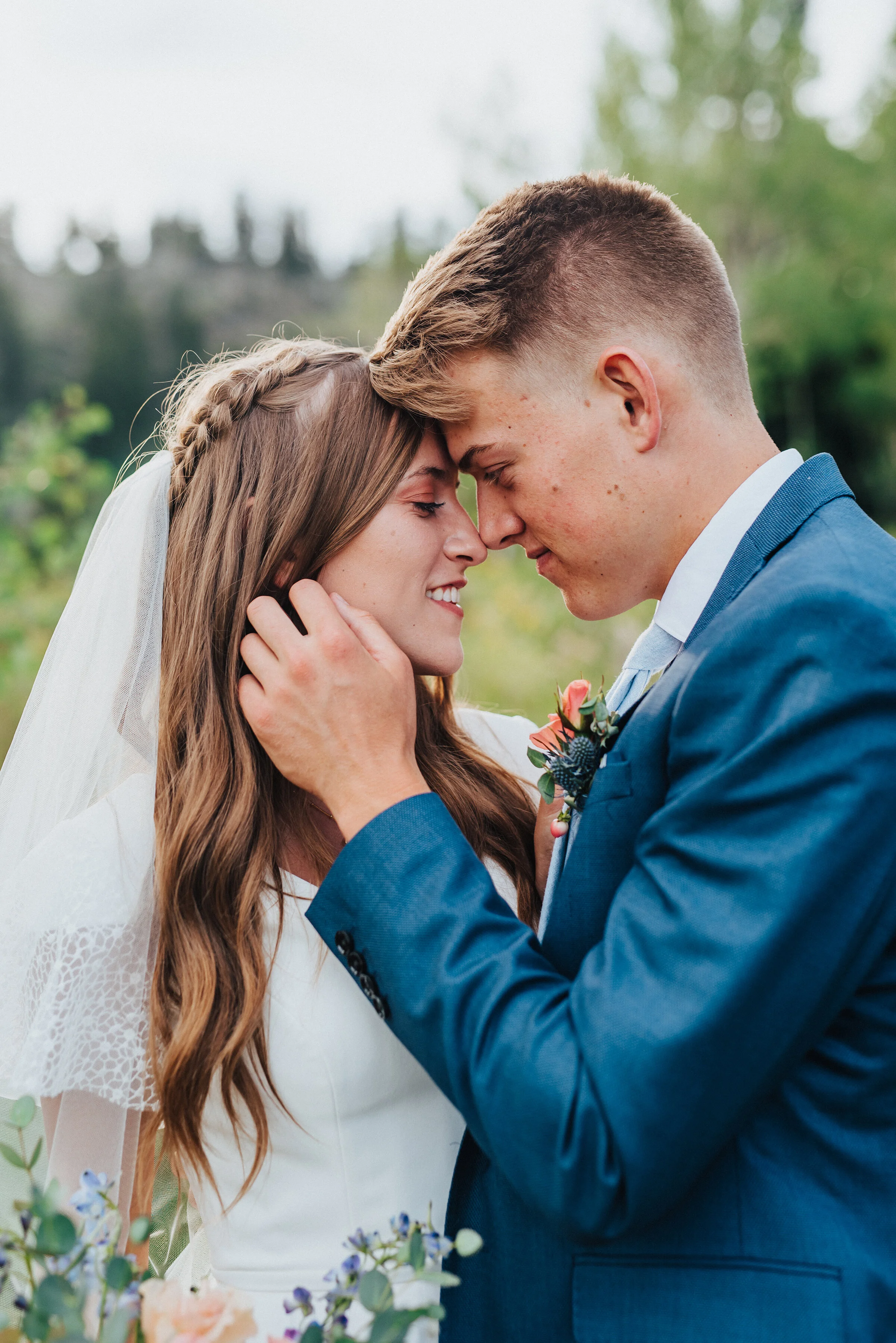  Beautiful bride with curled wedding hair and a small braid touching foreheads with her groom while he gently plays with her hair. Lace wedding dress wedding detail photography wedding photography in northern utah tony grove wedding formals wedding p