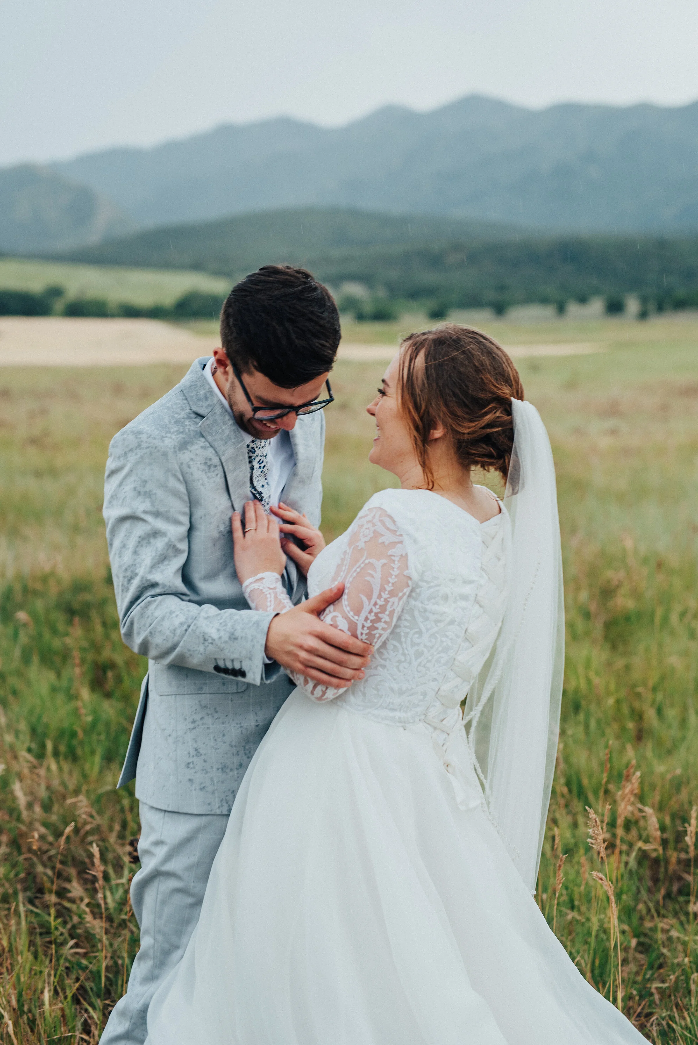  A sudden downpour during this bridal session by Kristi Alyse Photography in Logan, Utah, encouraged this bride and groom’s playful side. brides hands on grooms chest laughing, rolling green utah hills, logan utah professional photographer, utah moun