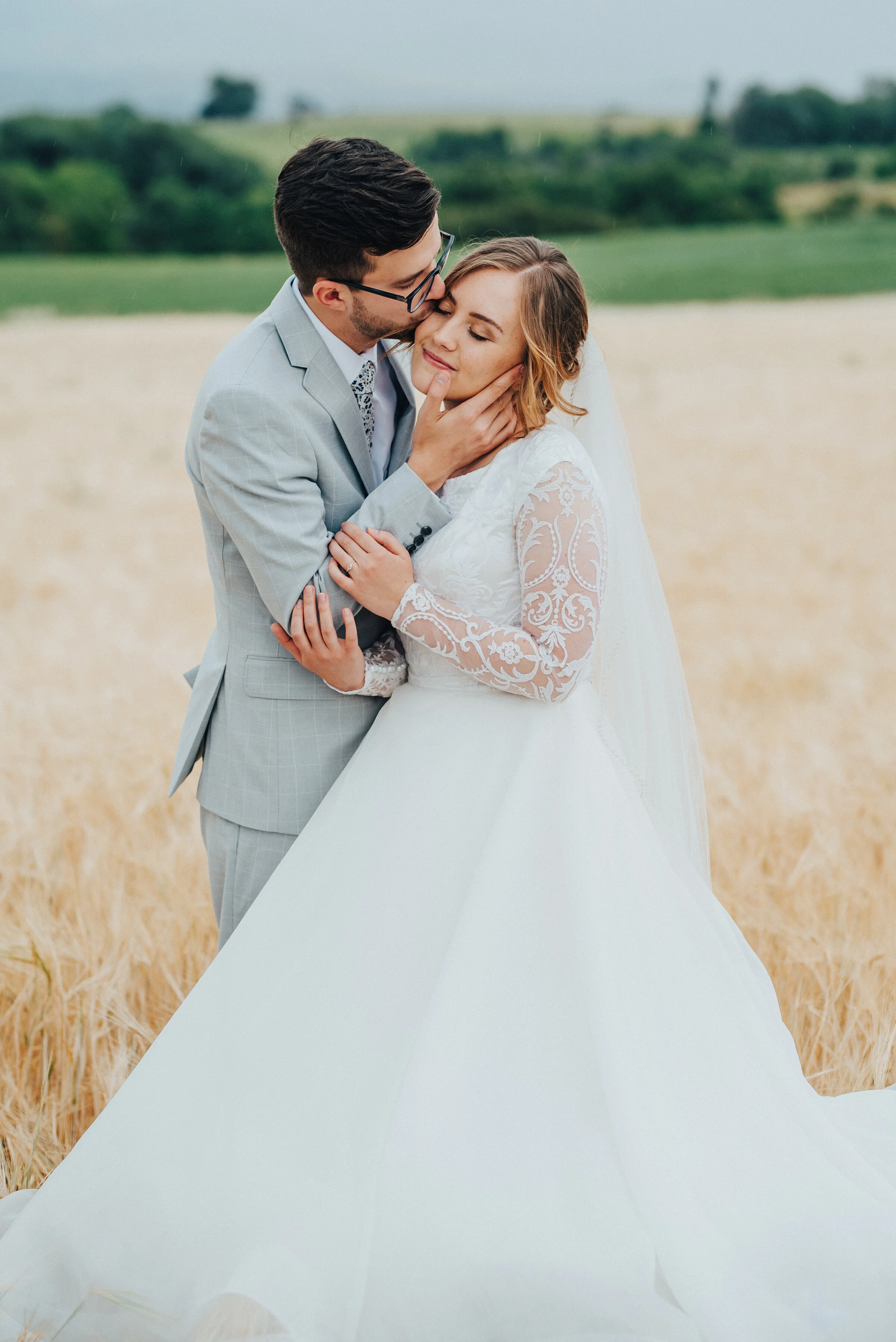  A tender moment during this bridal session by Kristi Alyse Photography in Mendon, Utah, filled with forehead kisses and gentle embraces. soft side hug bridal photo, face cupping forehead kissing, authentic bridal photos, mendon utah professional wed