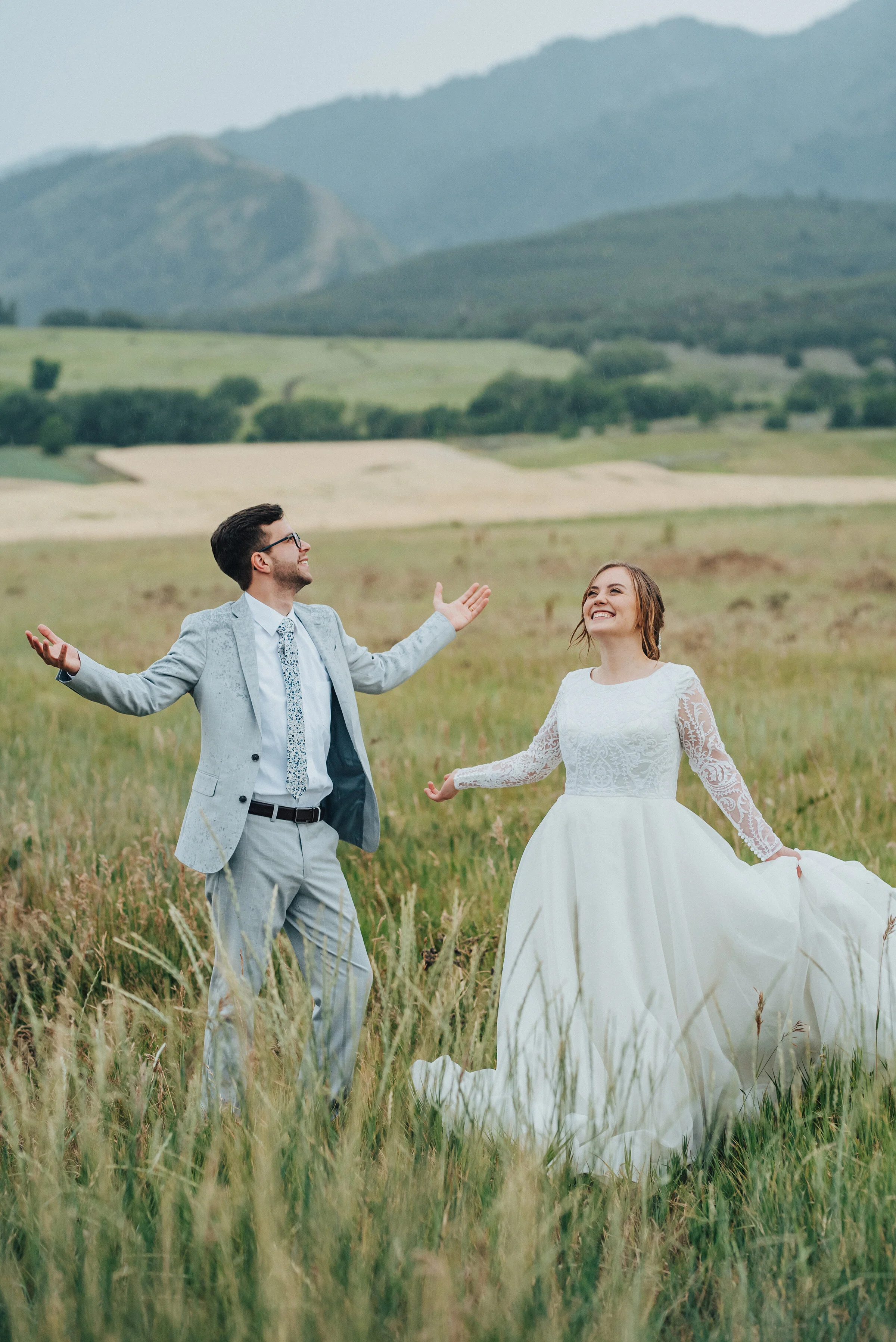  This Sound of Music-esque bridal session by Kristi Alyse Photography in Logan, Utah, was filled with glee, dancing, and rain! dancing in the rain, rainy bridal session, hands in the air during the rain, gloomy romantic bridal lighting, modest weddin