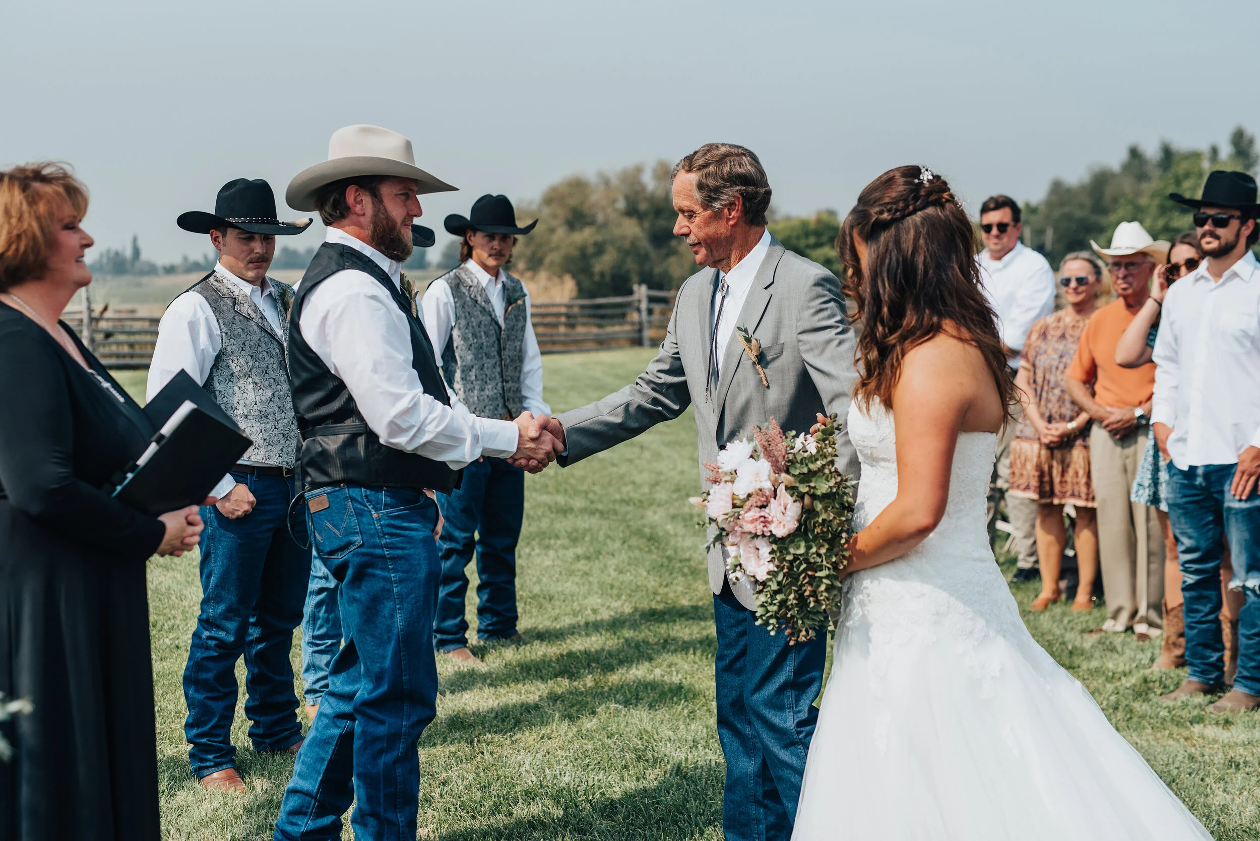 A blissful bride eagerly anticipates the start of her southern styled wedding ceremony shot by  Kristi Alyse Photography in Cache Valley Utah. groom wearing jeans, southern wedding, cowboy hat wedding, black cowboy hat groomsmen, bearded groom, stra…