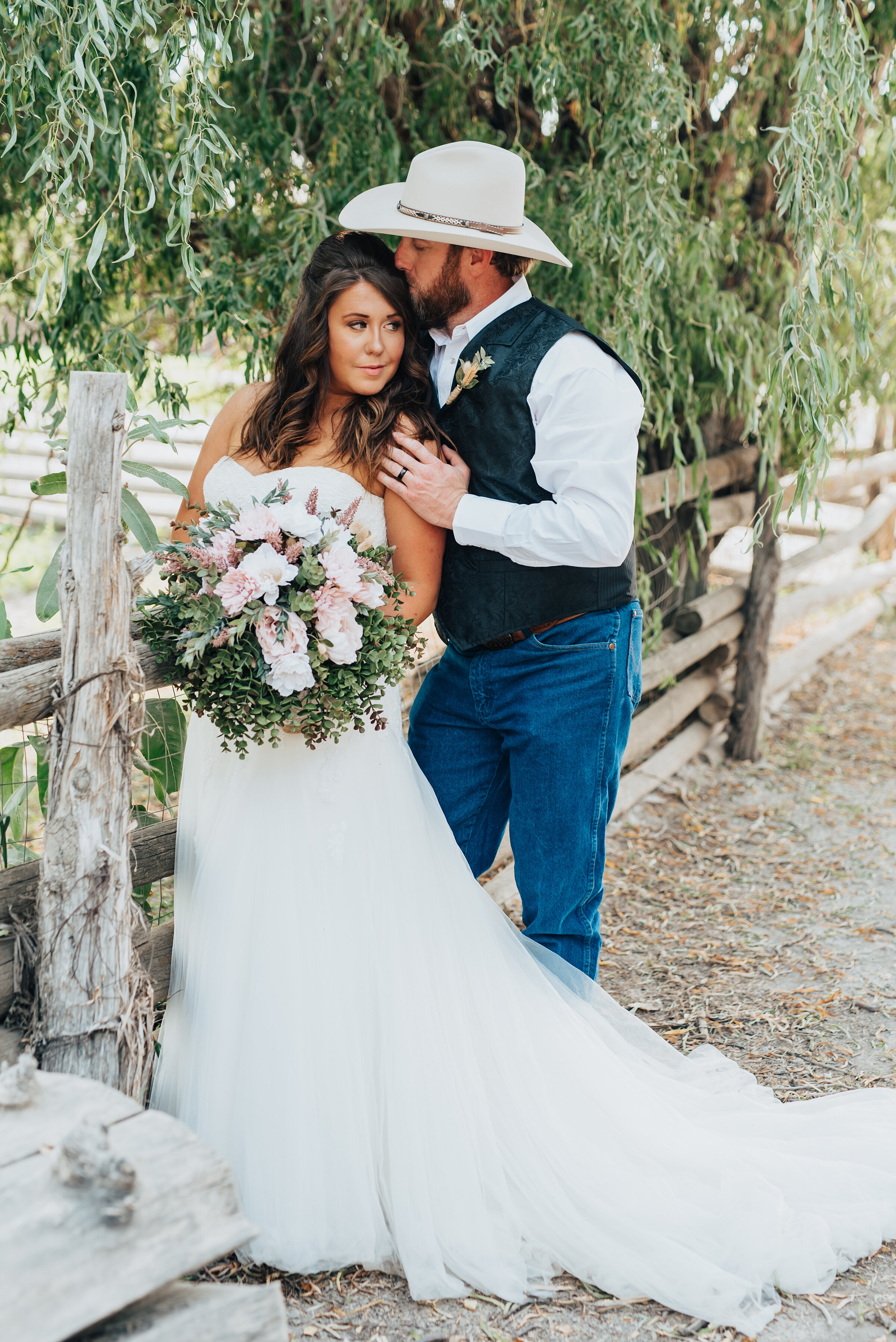  Blowing willow trees and wood fences add the perfect backdrop to this southern ranch wedding shot by Kristi Alyse Photography in Logan, Utah. bride and groom forehead kiss, side hugging, blush pink and white wedding bouquet, strapless sweetheart wed