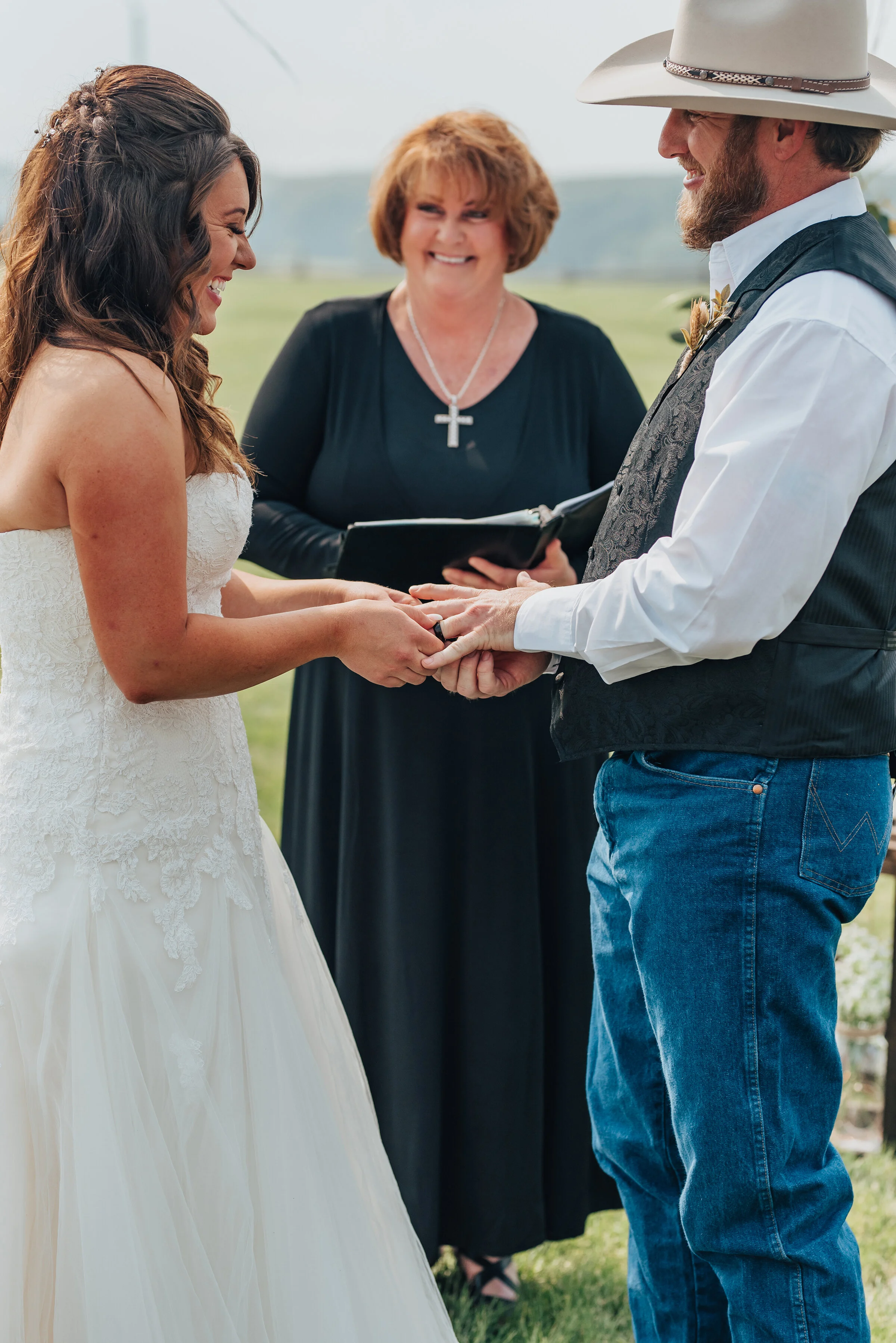  Kristi Alyse Photography capture intimate moments during an outdoor ranch wedding ceremony in Wellsville, Utah. Bride and groom exchange wedding rings, woman minister, outdoor wedding ceremony, ranch wedding, logan utah wedding, professional wellsvi